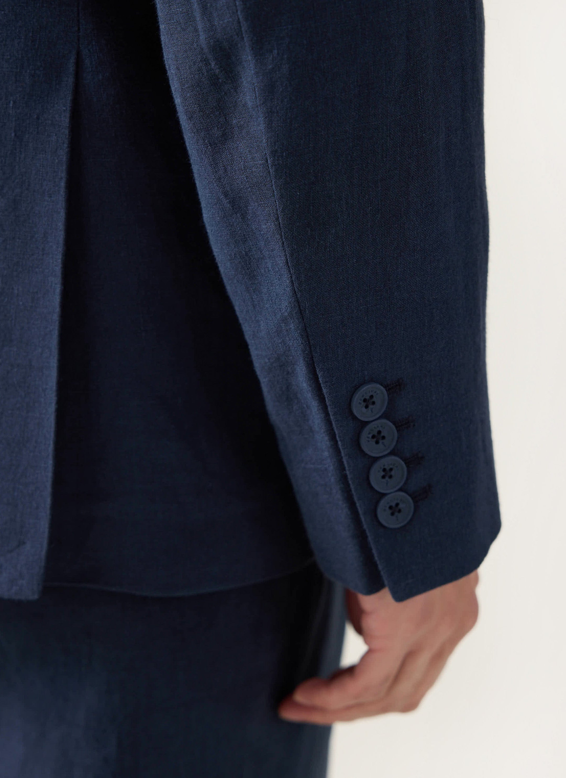 Close up of the cuff on the Percival navy tailored linen blazer, showing the four-button detail on the sleeve.