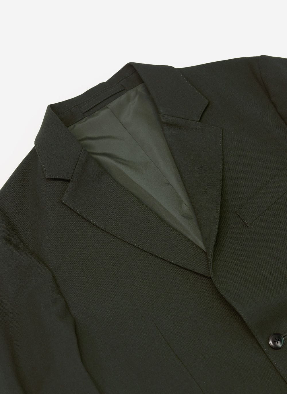 Close up shot of the Percival tailored wool blazer in forest green, showing the lapel, collar and inner lining.