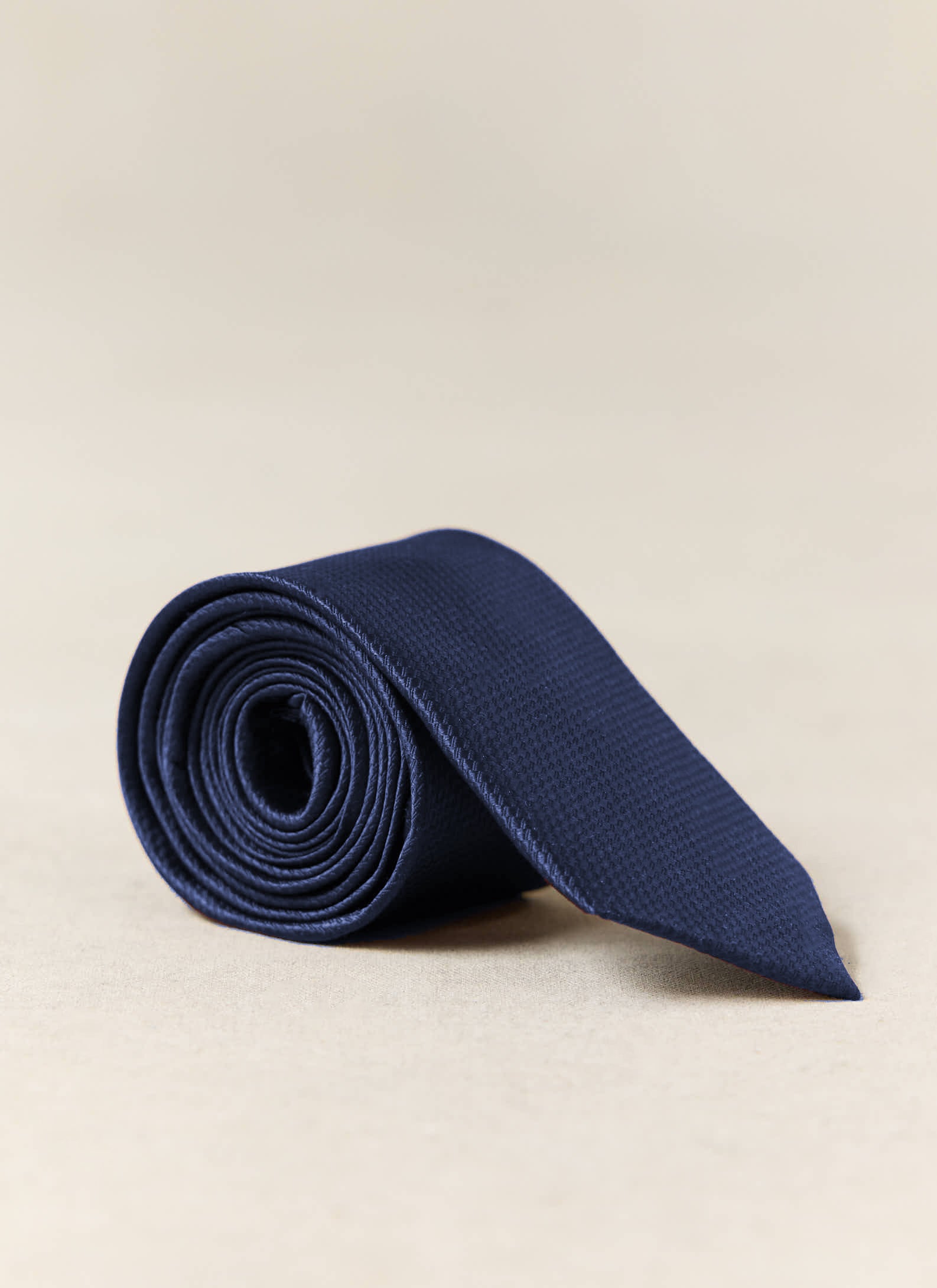 Navy, rolled to show its textured weave on a neutral studio background.