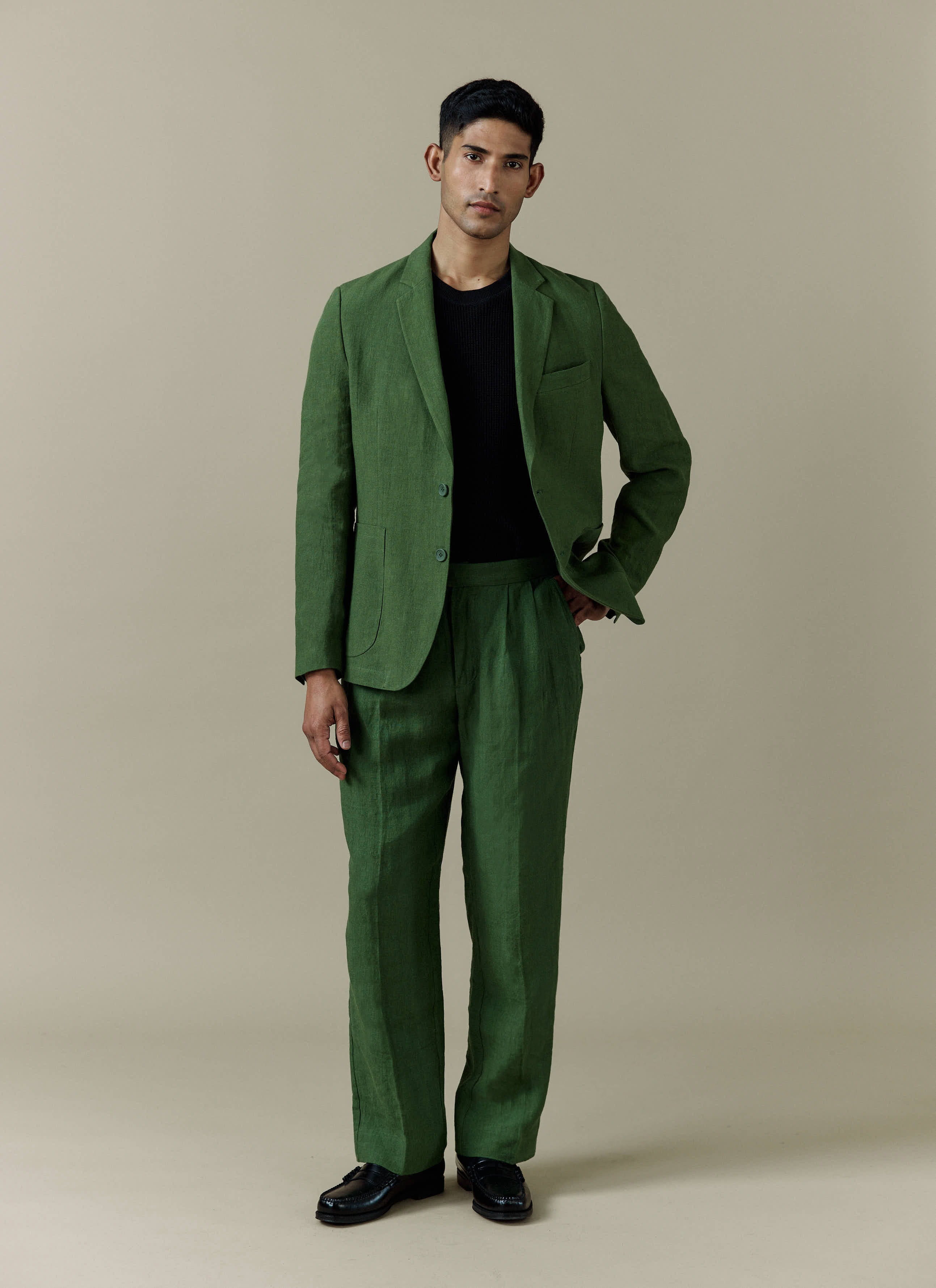 Forest green Percival tailored linen blazer and matching trousers worn by a model in a full-length studio shot.