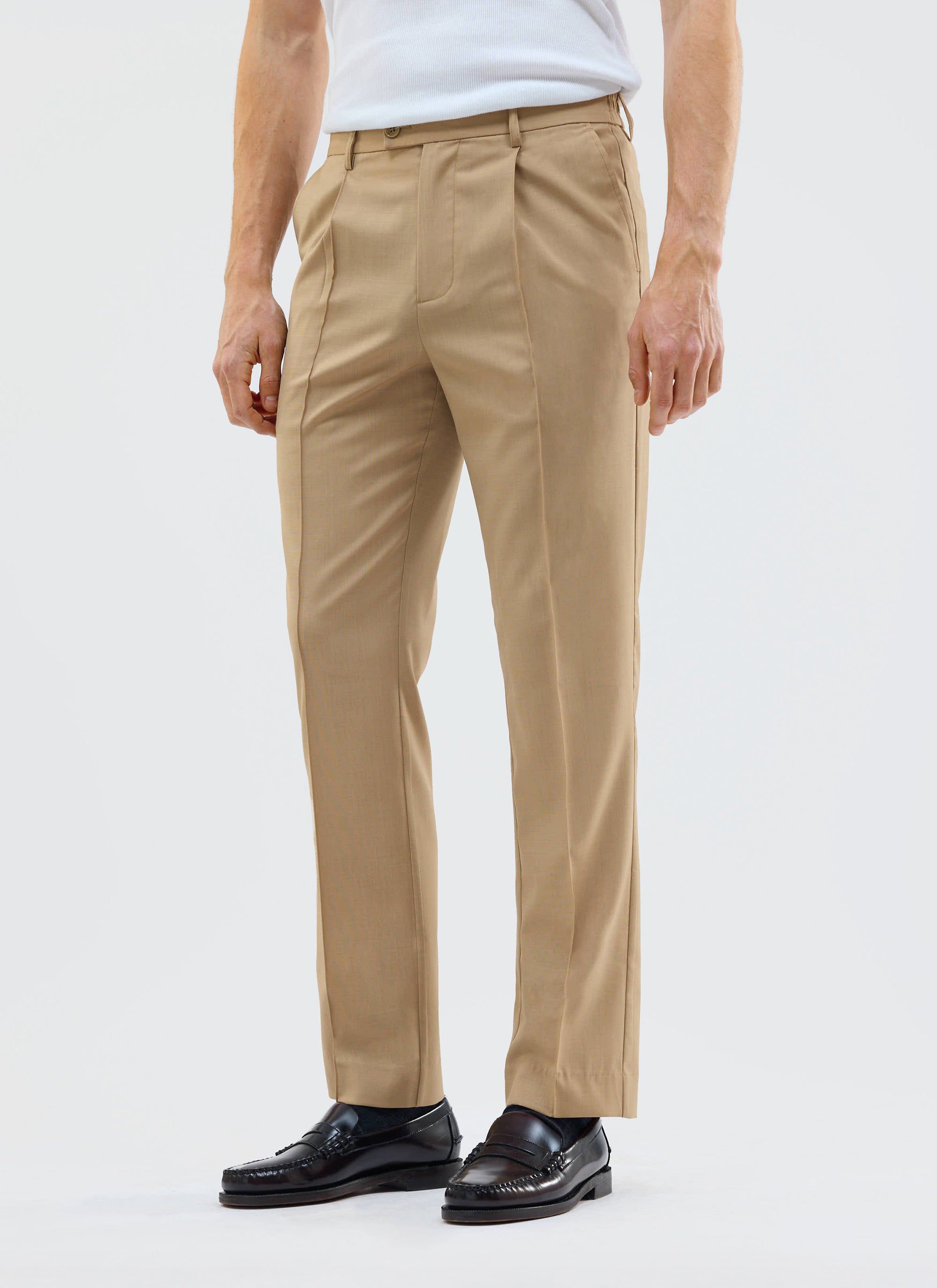 A model wears the Percival Tailored Elasticated Waist Trousers in tan with a white vest and black loafers.