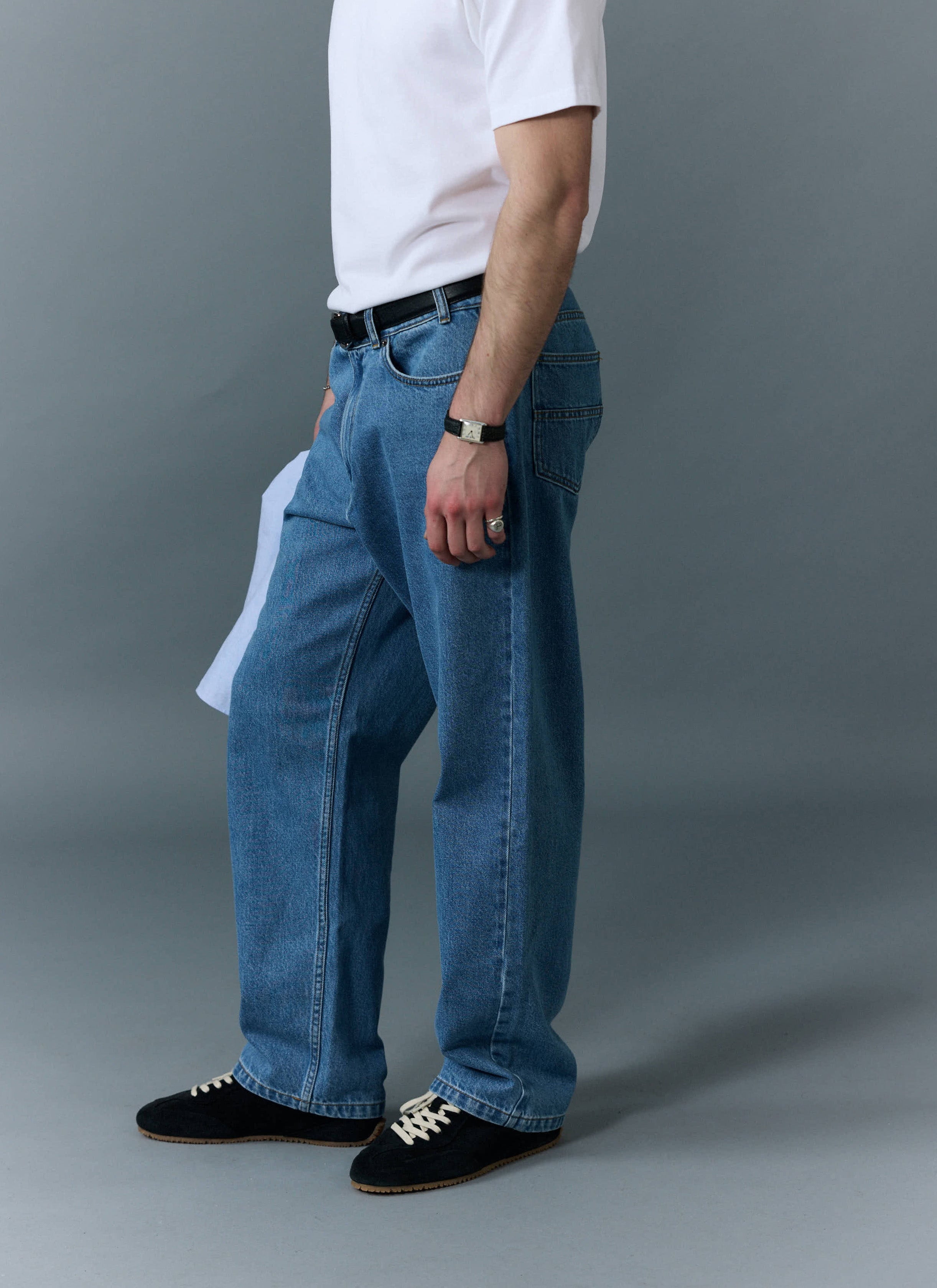 A model shot from the side, showing the relaxed fit of the Percival Wide Leg Denim Jeans in light wash blue.