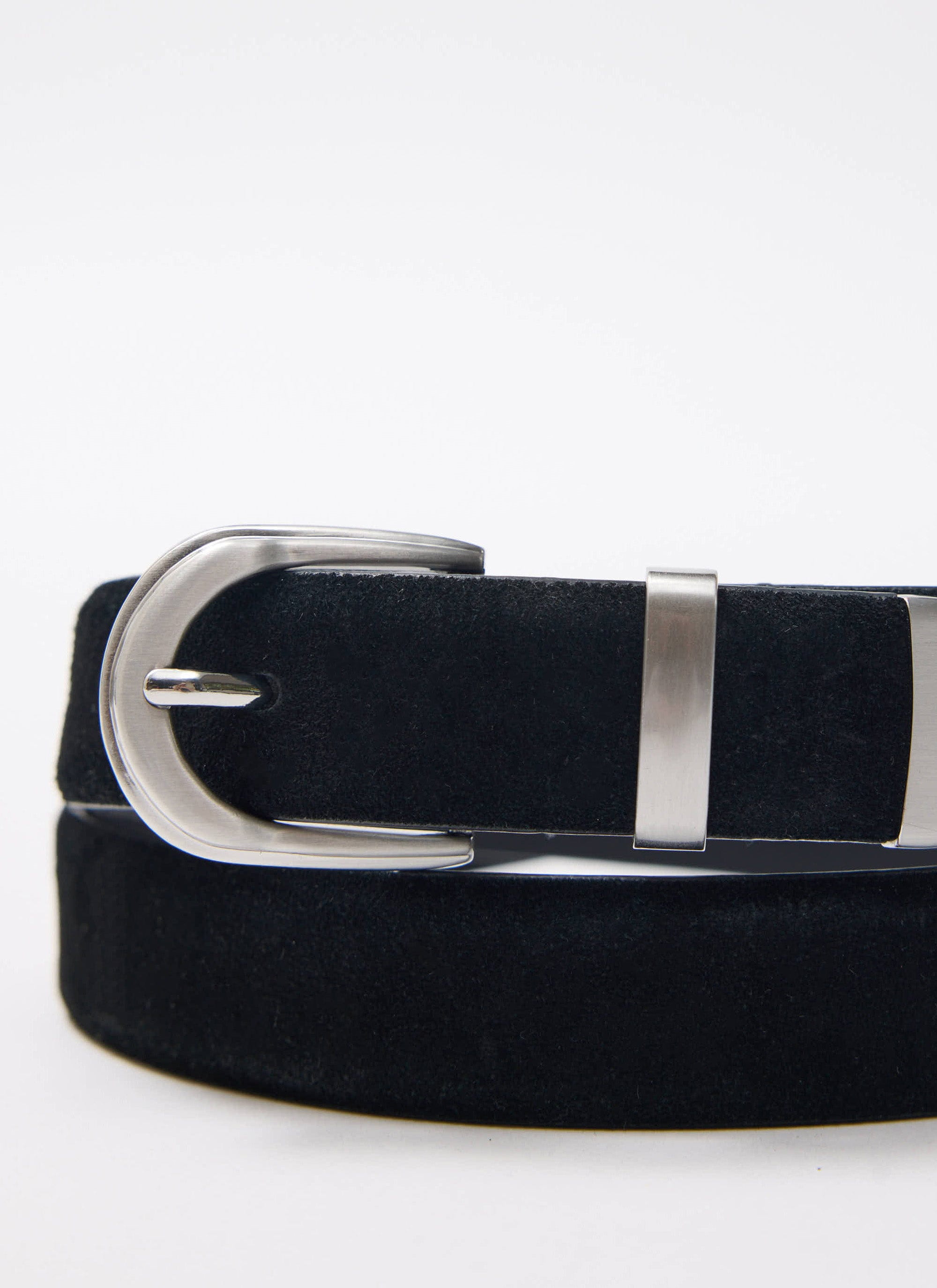 A close-up of the black suede Percival x Warren belt, showing the brushed silver buckle and western-style metal tip.