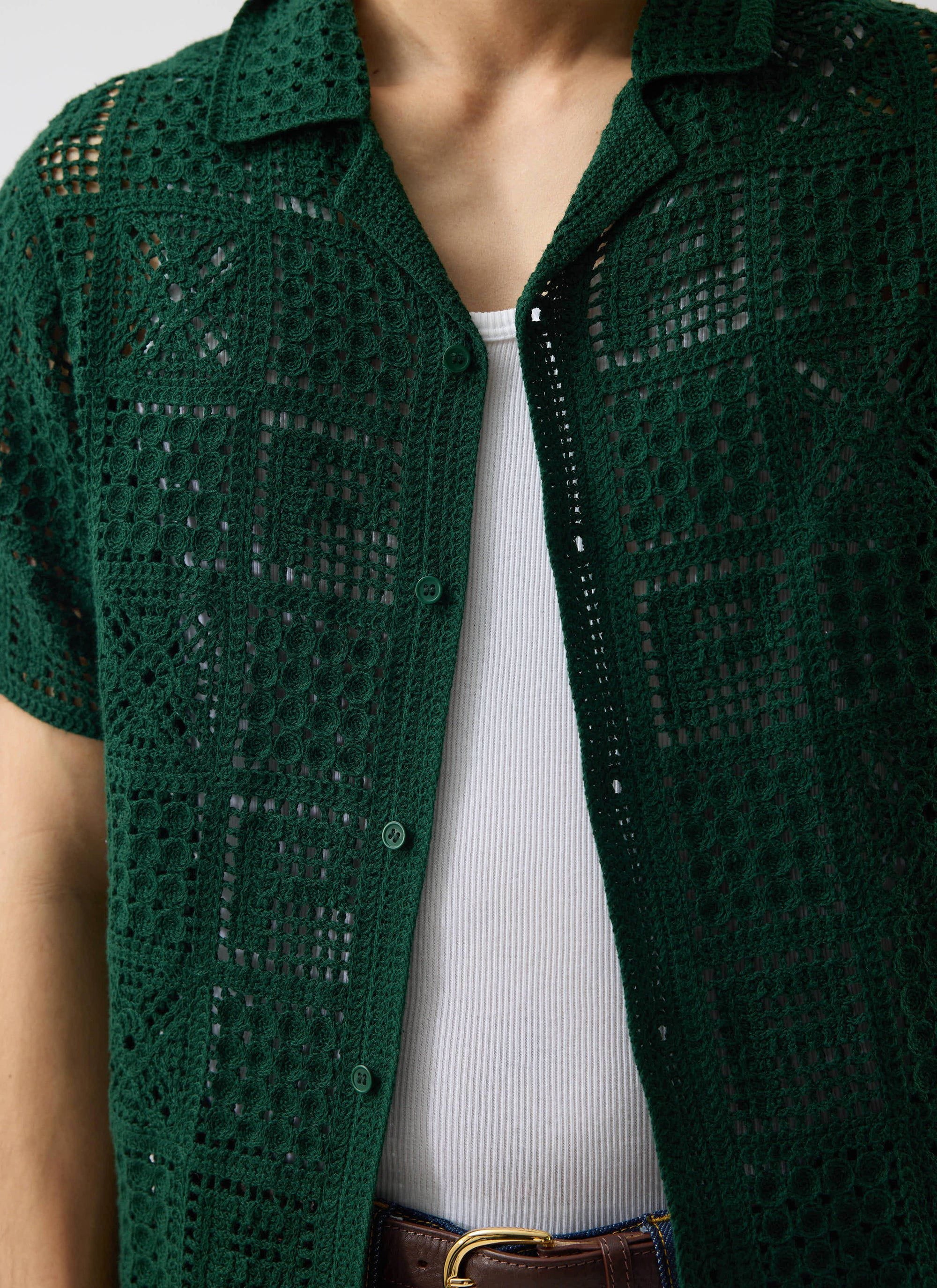 A close-up of the Percival Crochet Groundsman Shirt in forest green, showing the crochet knit layered over a white vest.