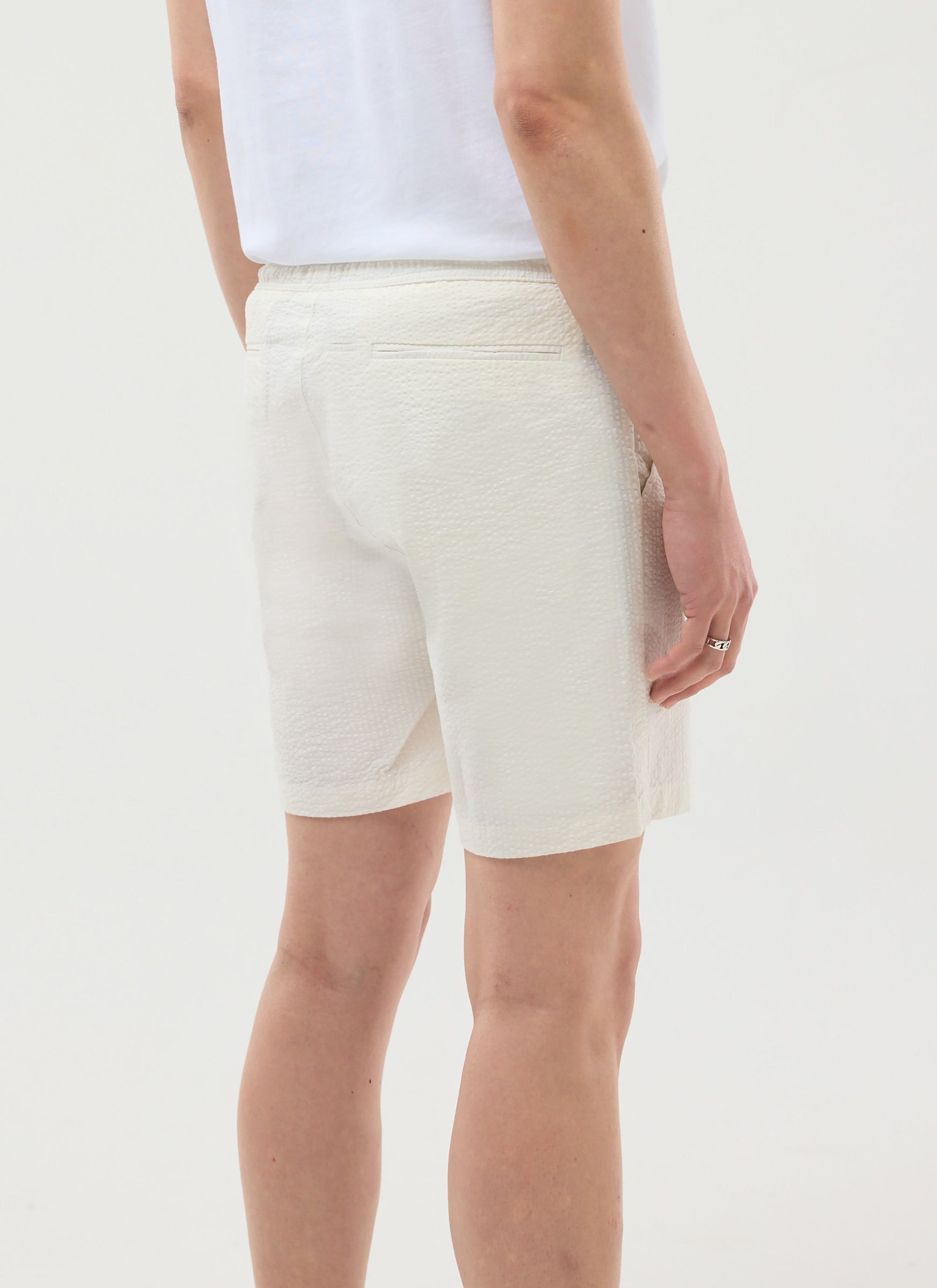 Rear view of a model wearing the Percival Classic Seersucker Shorts in cream, showing the textural fabric and fit.