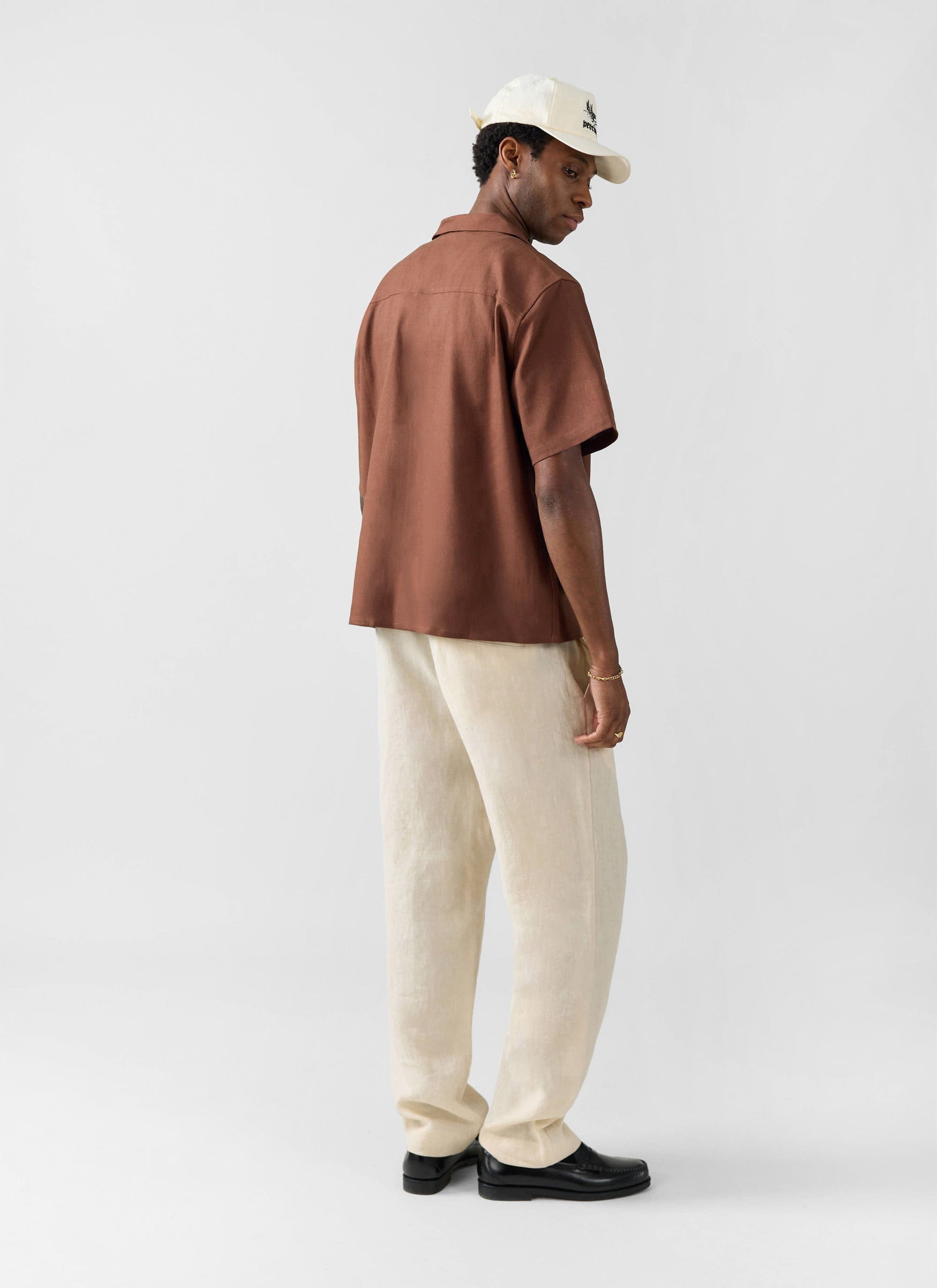 The Percival Short Sleeve Cuban Shirt in brown, a linen blend shirt, shown from behind on a model.