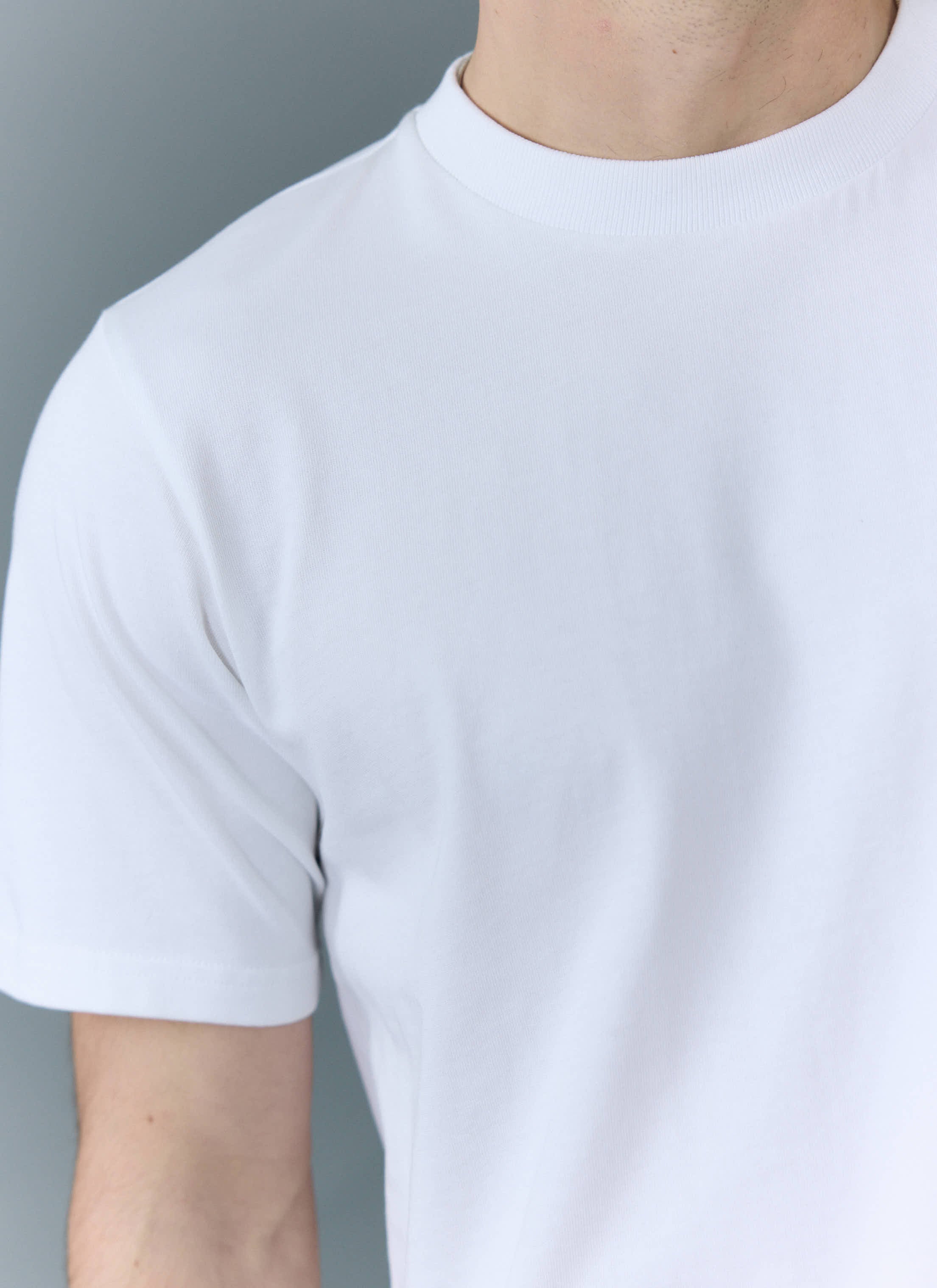 A close-up of a model wearing the Percival Cropped Regular Fit T-Shirt in white organic cotton.