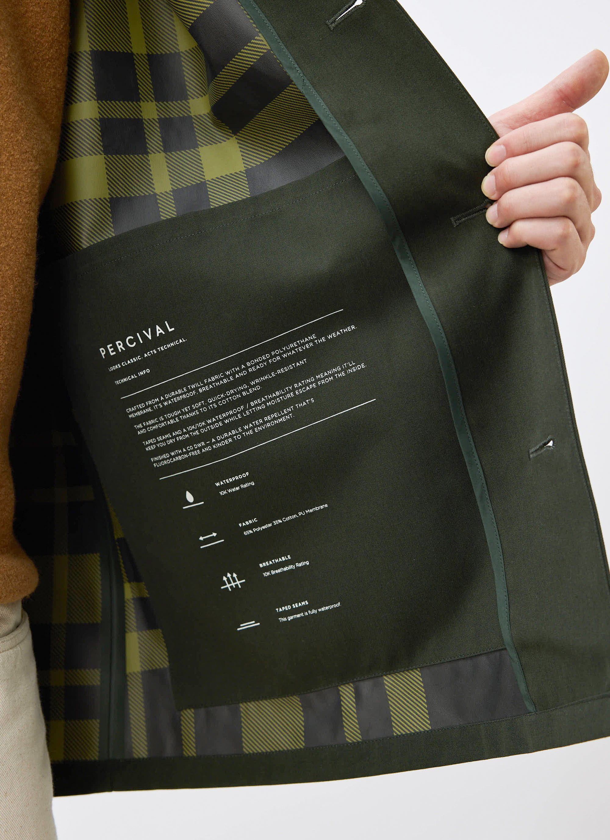 A close-up of the technical details inside the Percival Sherlock Trench Coat, showing the forest green check lining.