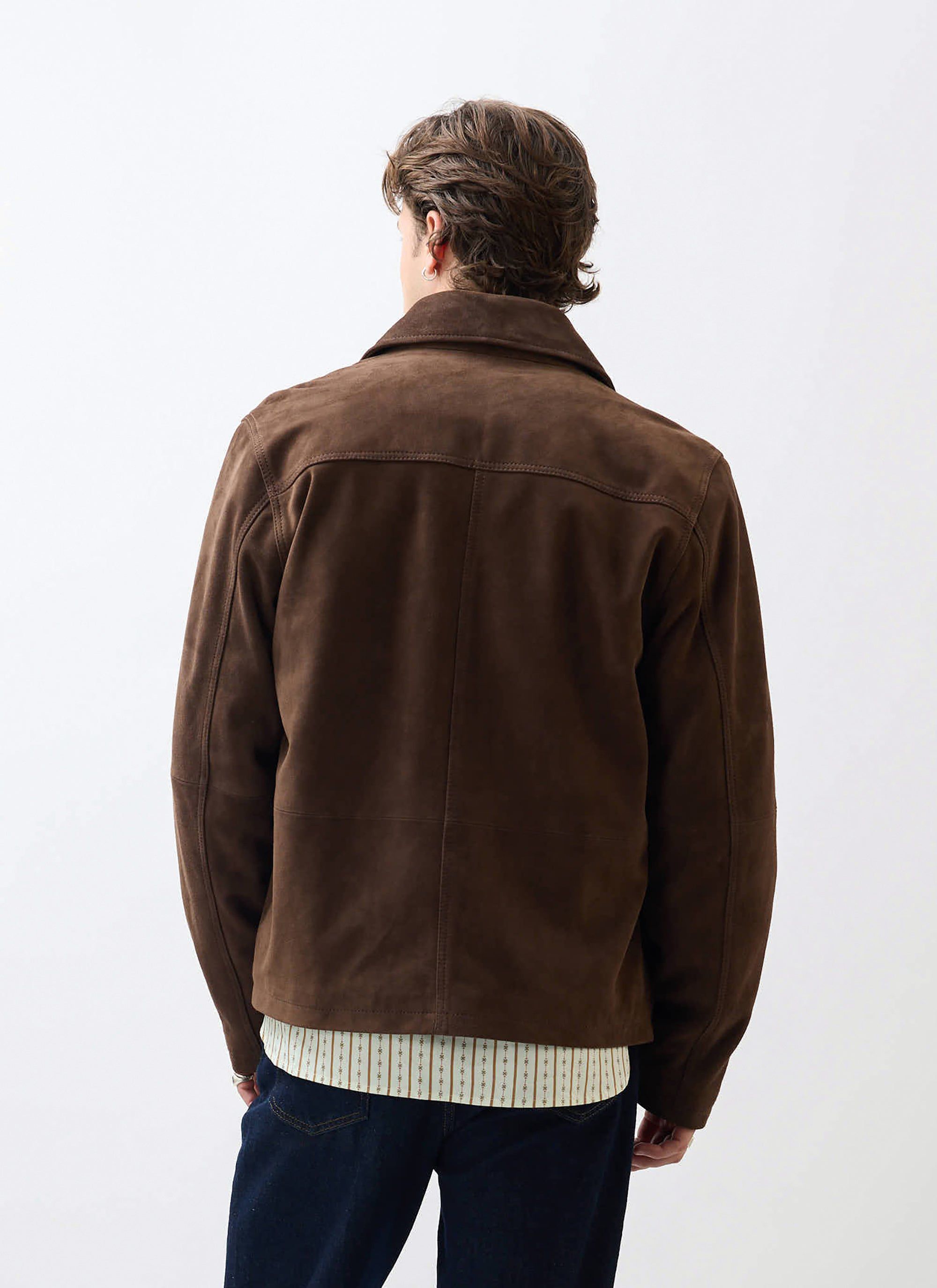 A model wears the Percival Prologue Soft Suede Jacket in espresso brown, seen from behind against a white background.