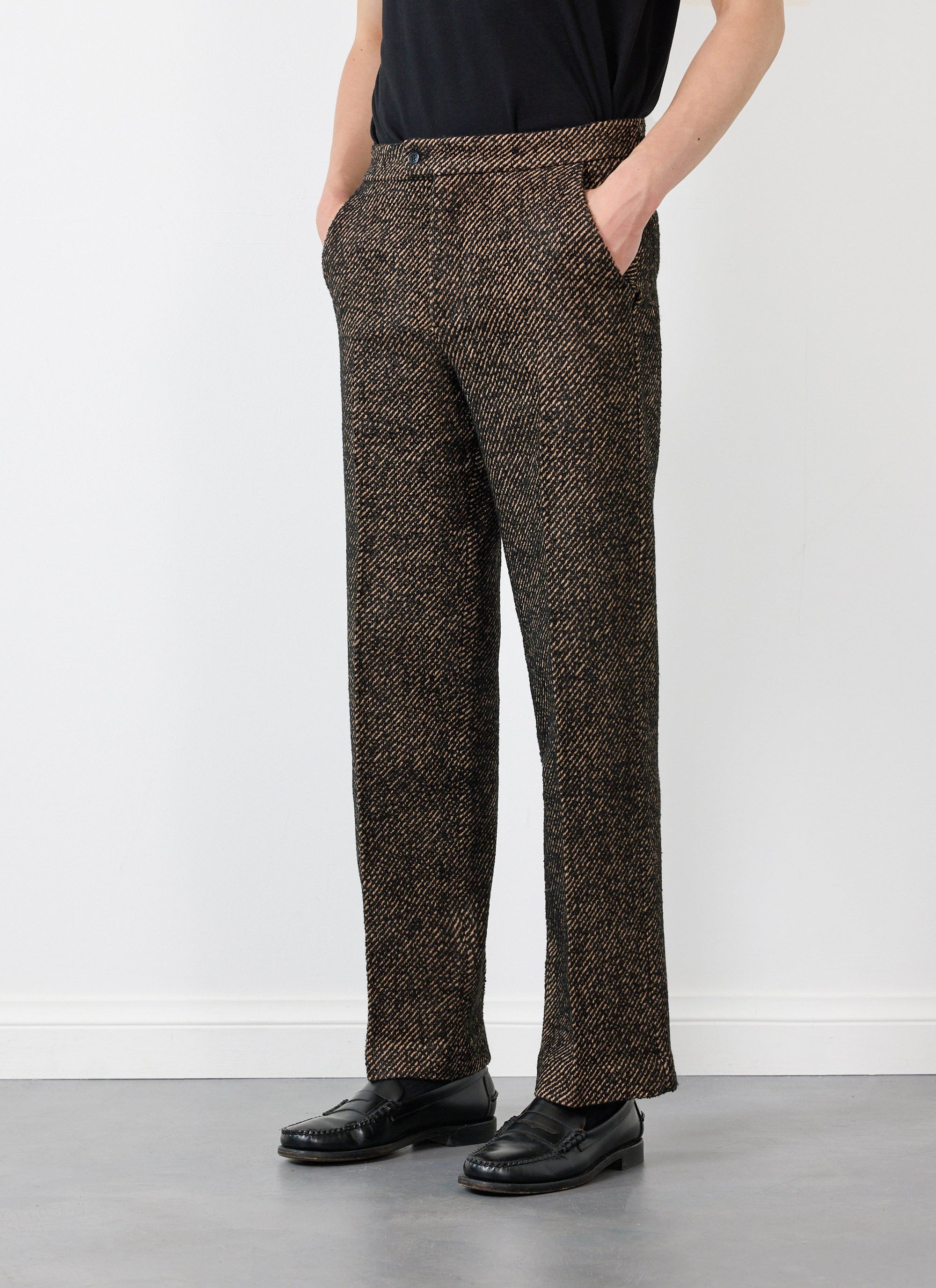 A model wears the Oak Twill Slack Trousers by Percival with a black top and loafers.