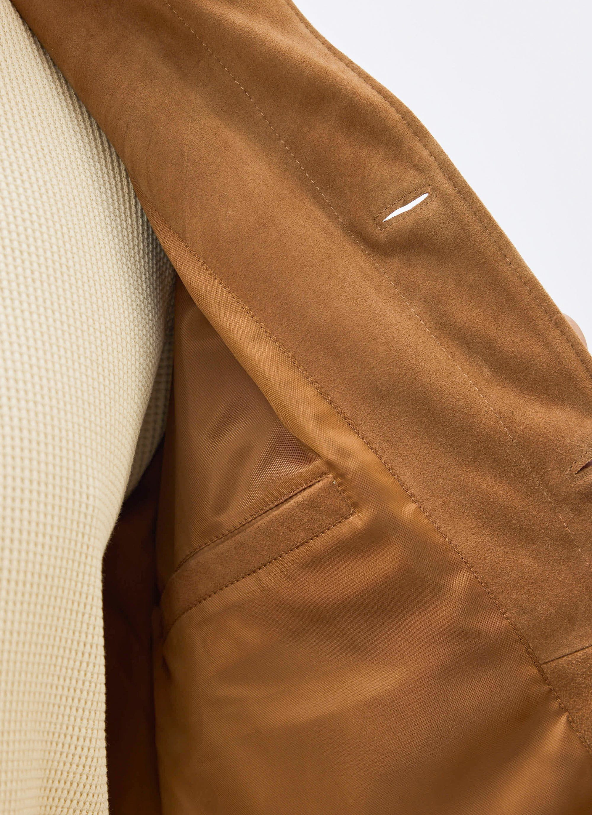 A close-up shot of the Percival Afterward Suede Chore Jacket in tan, detailing the soft lining and internal pocket.
