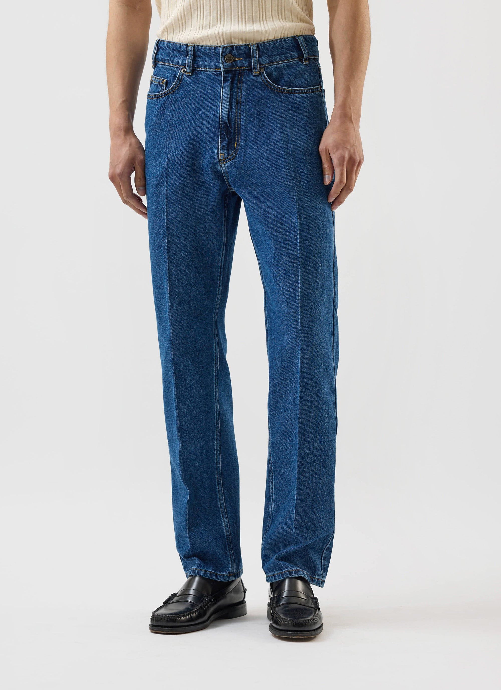 A model wears the Percival Stay Press Denim Jeans in a mid wash blue, showing the straight-leg fit and front crease.