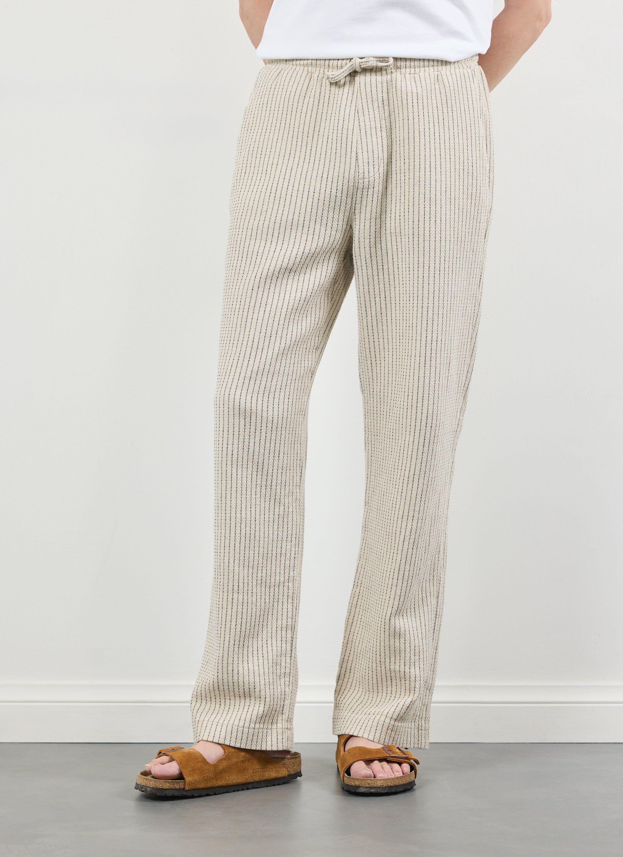 A model wears the Percival Sorrento Linen Trousers in ecru, showing the relaxed fit and pinstripe detail.