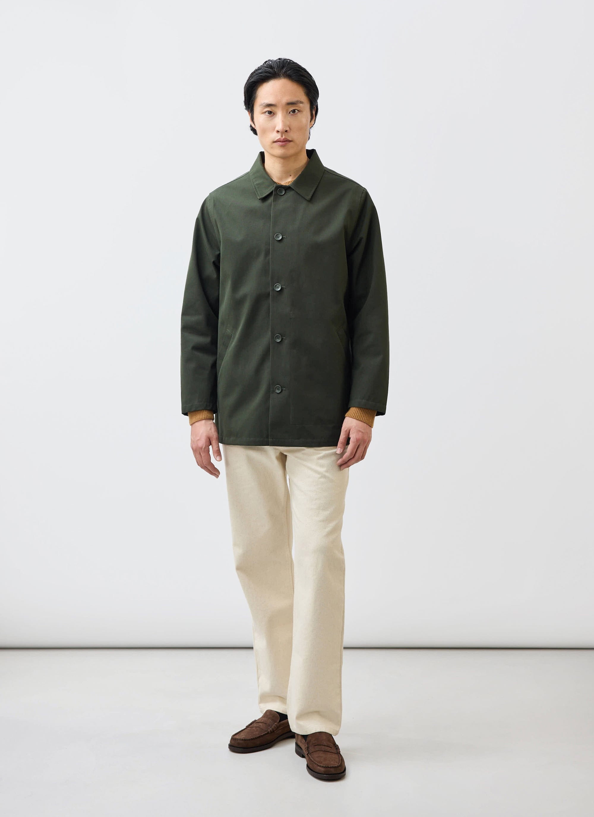 A man models the waterproof Percival Sherlock Short Trench Coat in Forest green against a plain studio background.