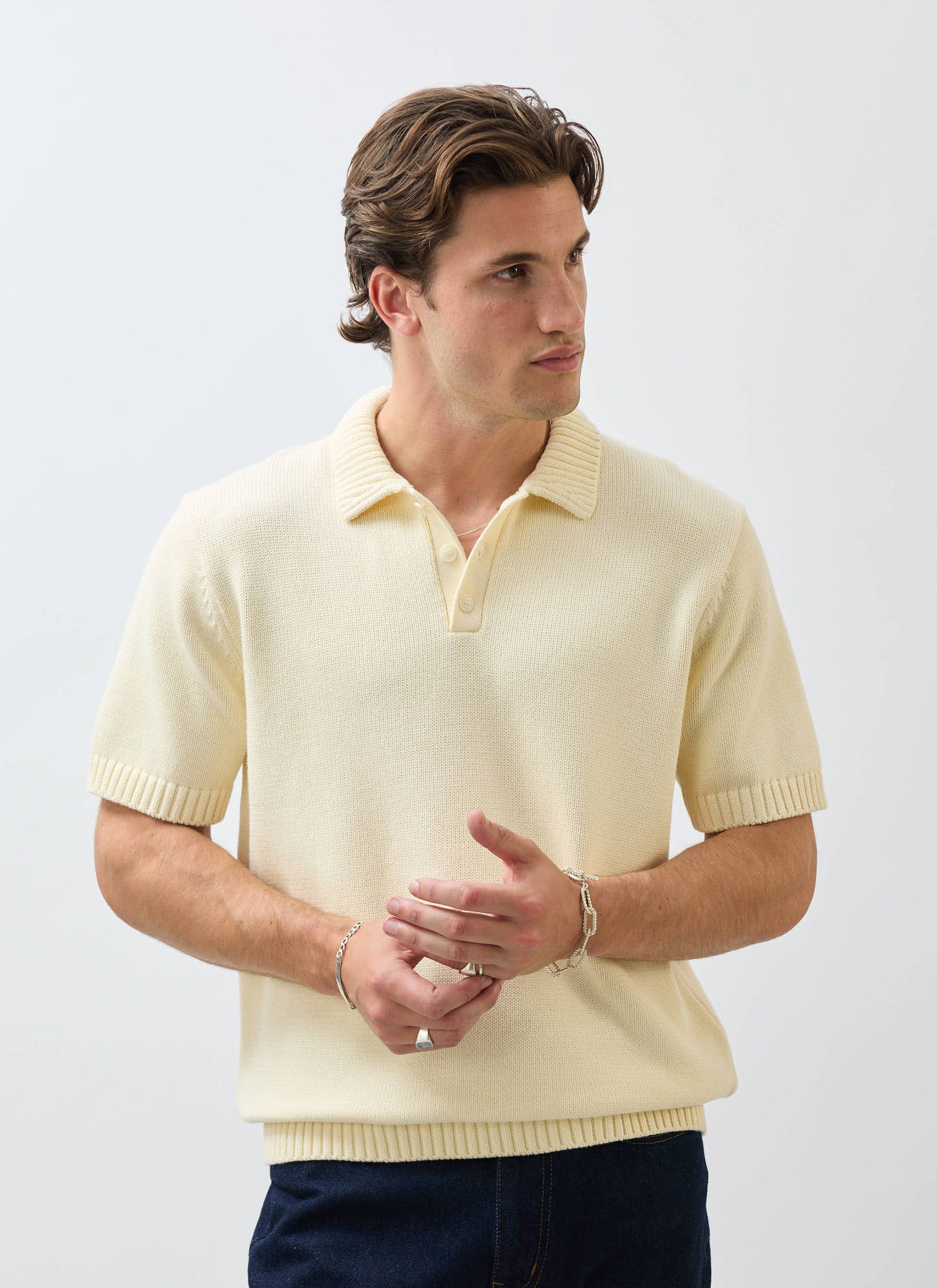 A model wears the Percival Verso Short Sleeve Knitted Shirt in ecru against a white studio background.