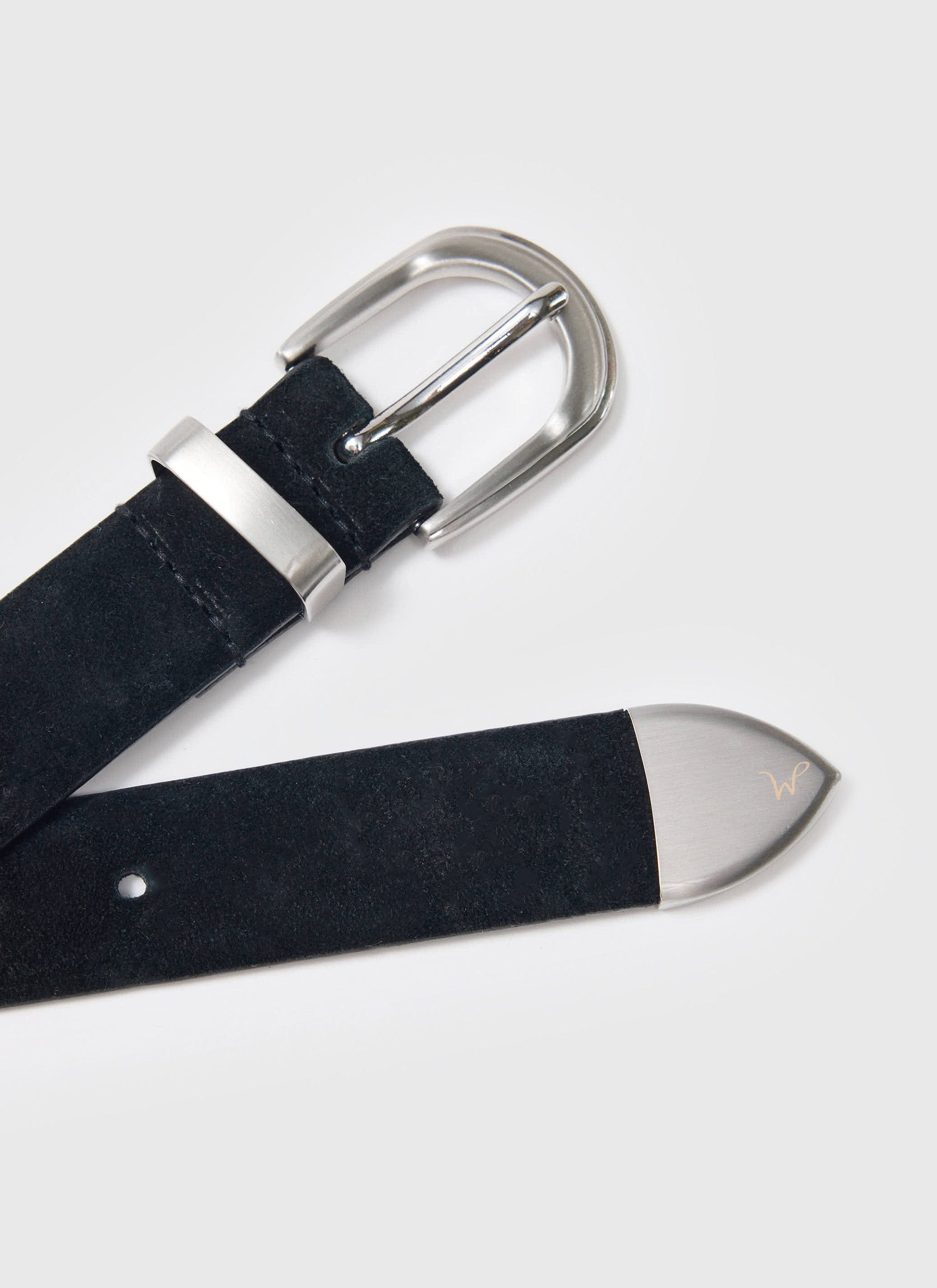 Close-up of the Percival x Warren Suede Belt in black, showing the silver buckle and engraved metal tip.