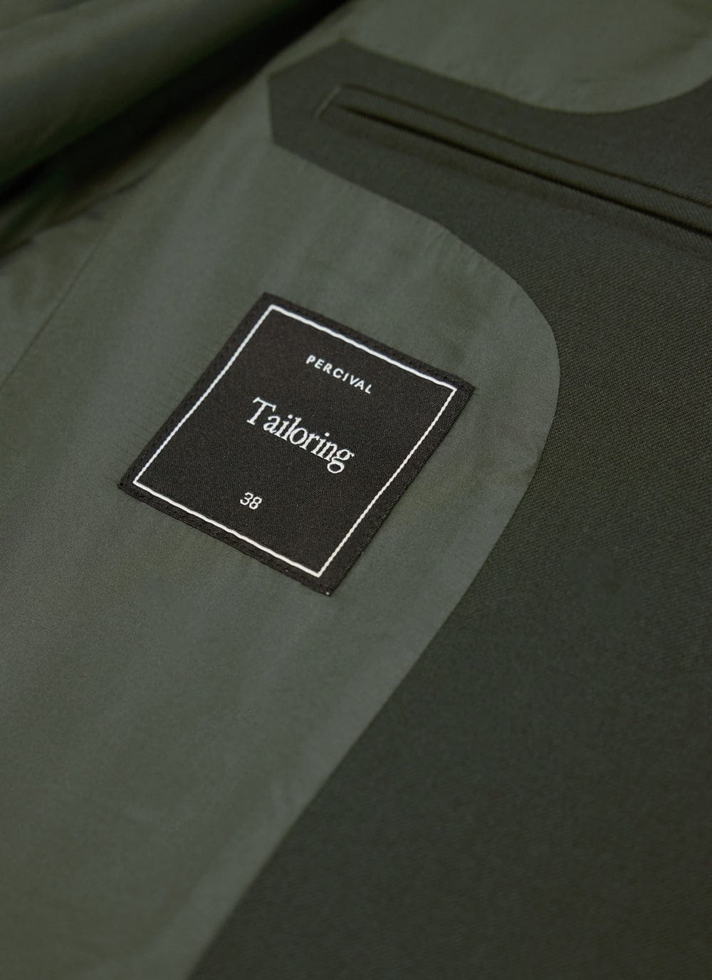 Close-up of the internal label and lining of the Percival Tailored Blazer in forest green wool.