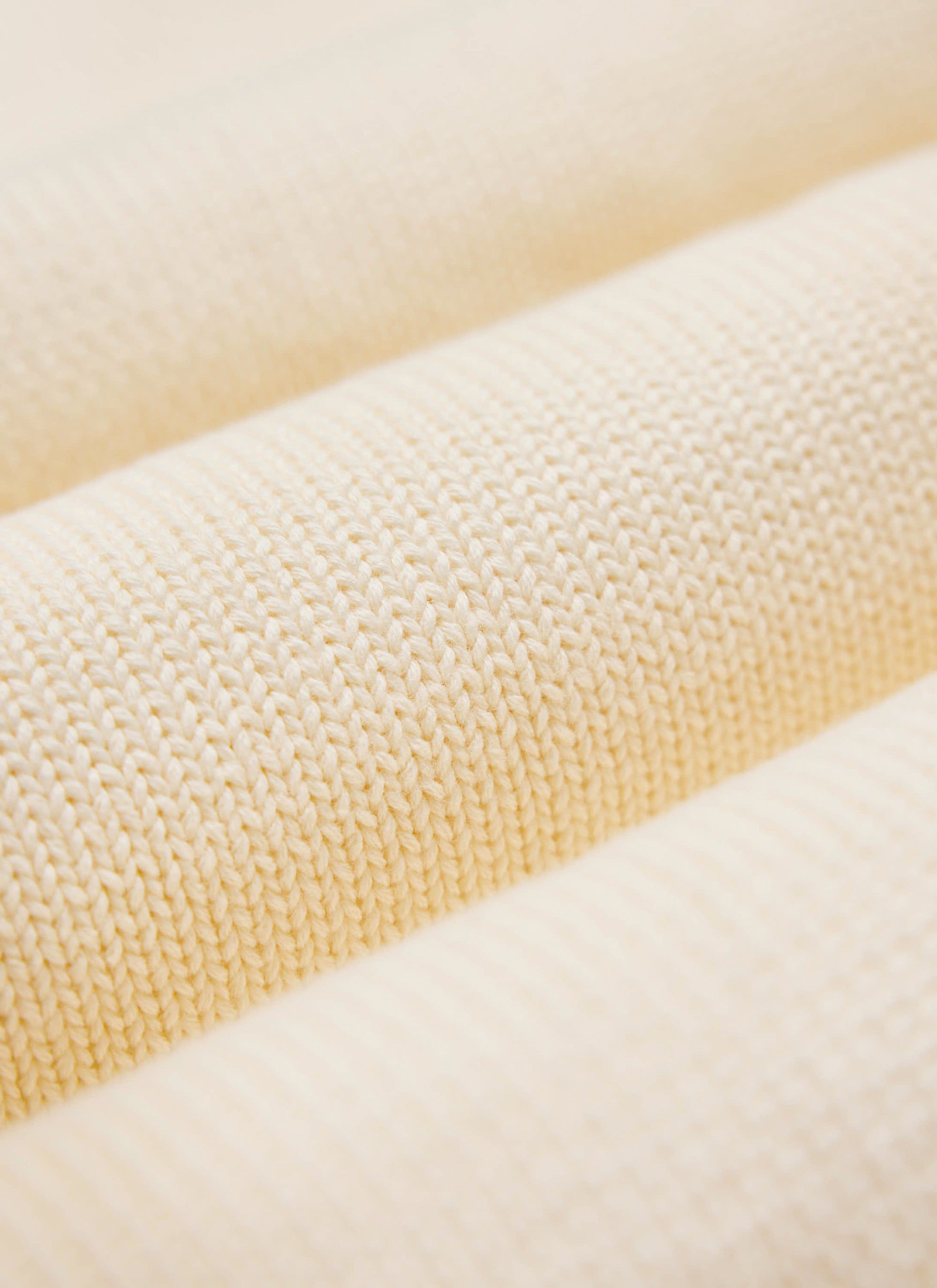 A close-up detail shot of the soft, ecru cream wool-blend knit used for the Public Library Jumper by Percival.
