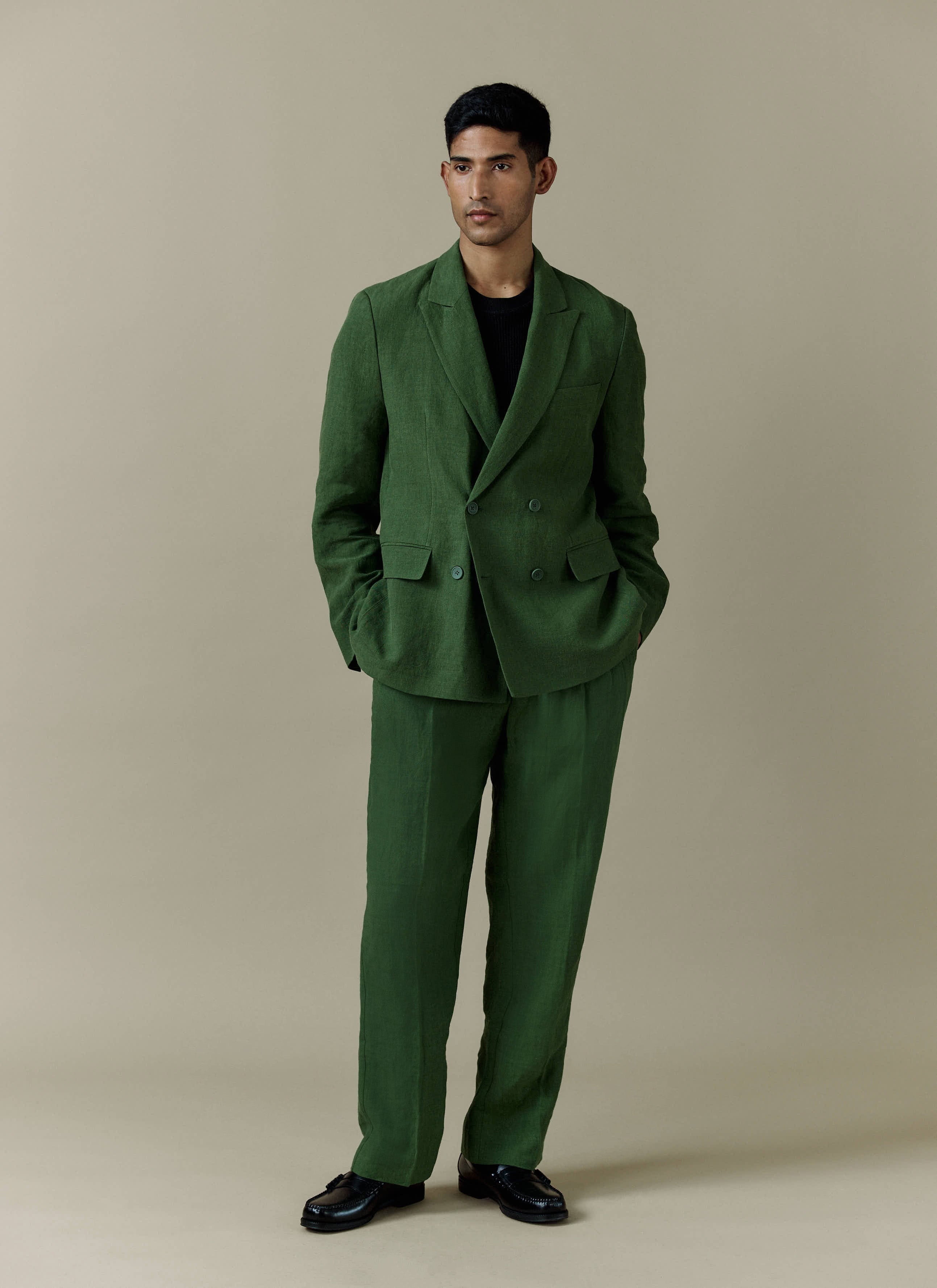 A model wears the Percival forest green linen Clifton double-breasted blazer and matching tailored suit trousers.