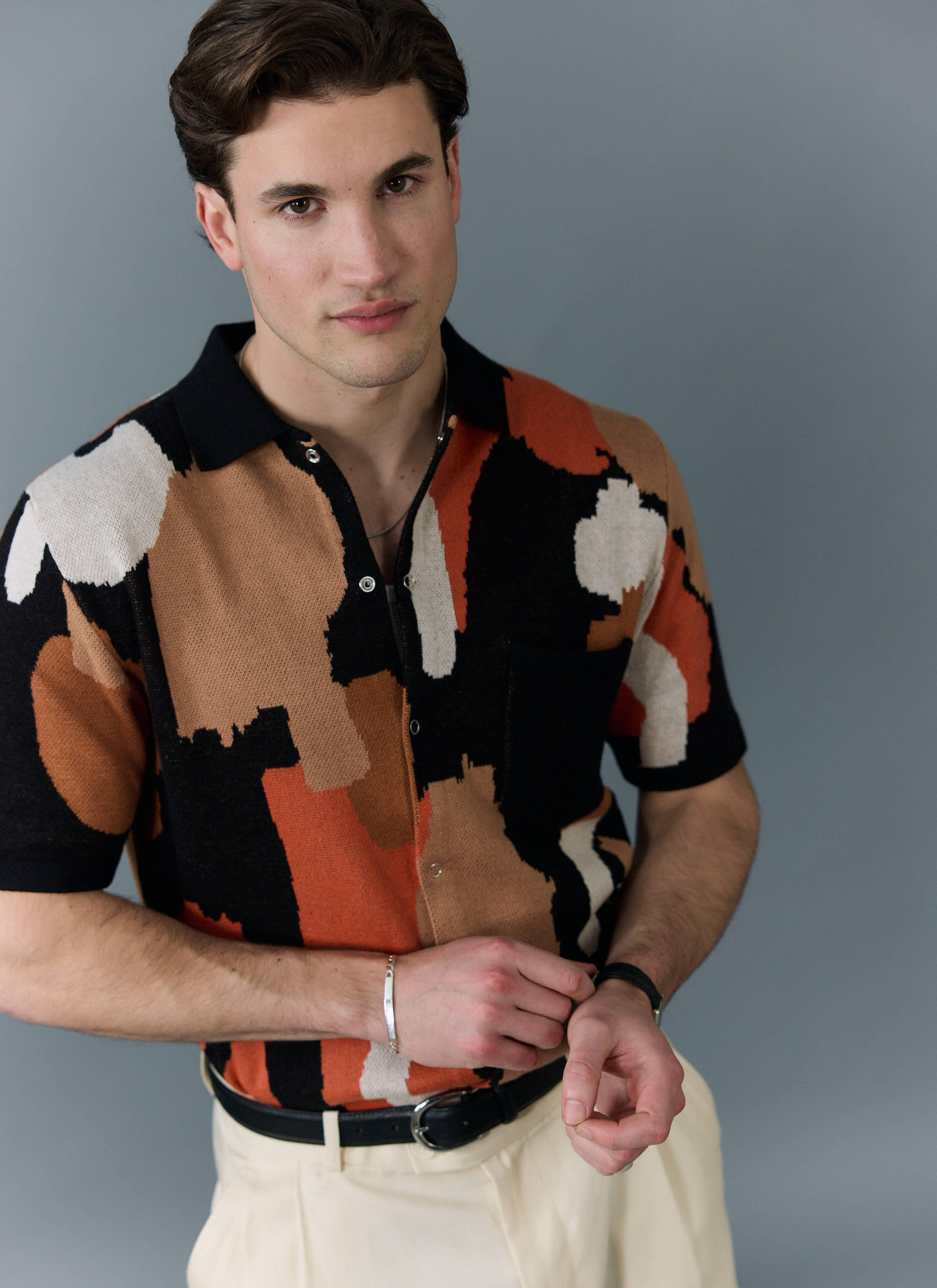 A model wears the Impressionist Jacquard Shirt from Percival, a knitted cotton shirt with an abstract multi-colour pattern.
