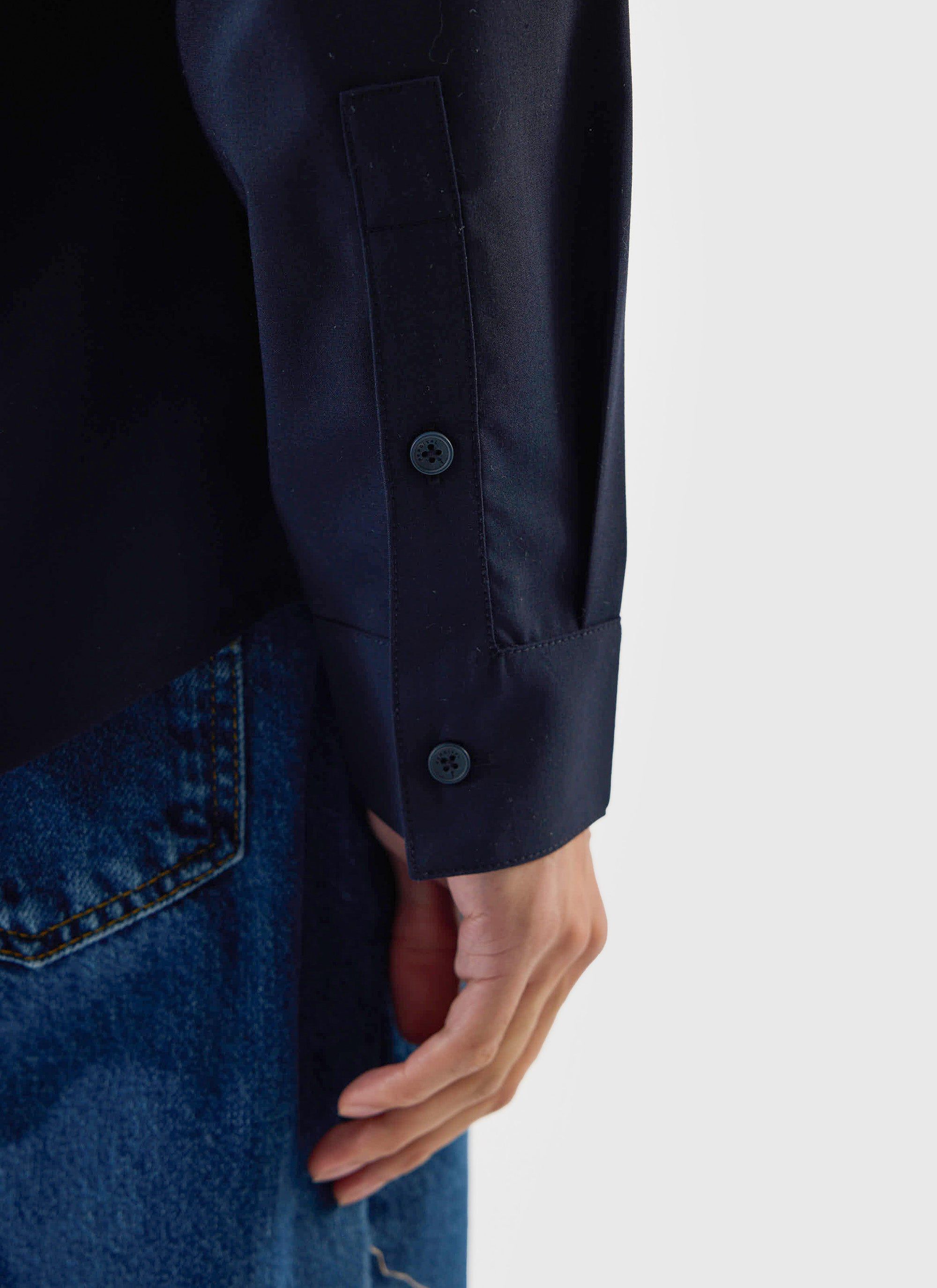 A close-up shot of the sleeve cuff on the Percival x Warren Pleated Shirt in navy blue.