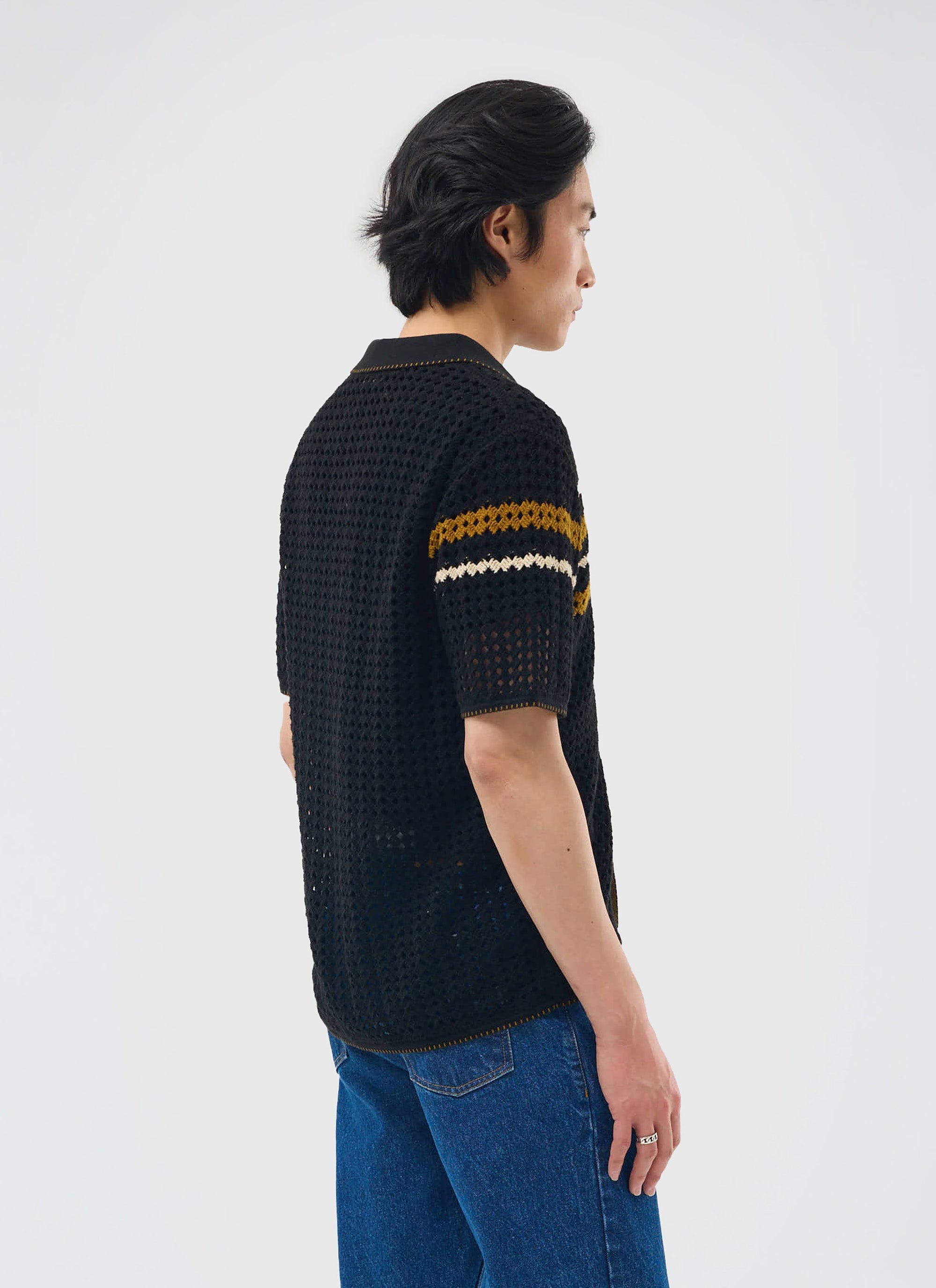 A model wears the black Percival Pesaro Knitted Shirt, showing the relaxed fit and striped sleeve detail from the back.