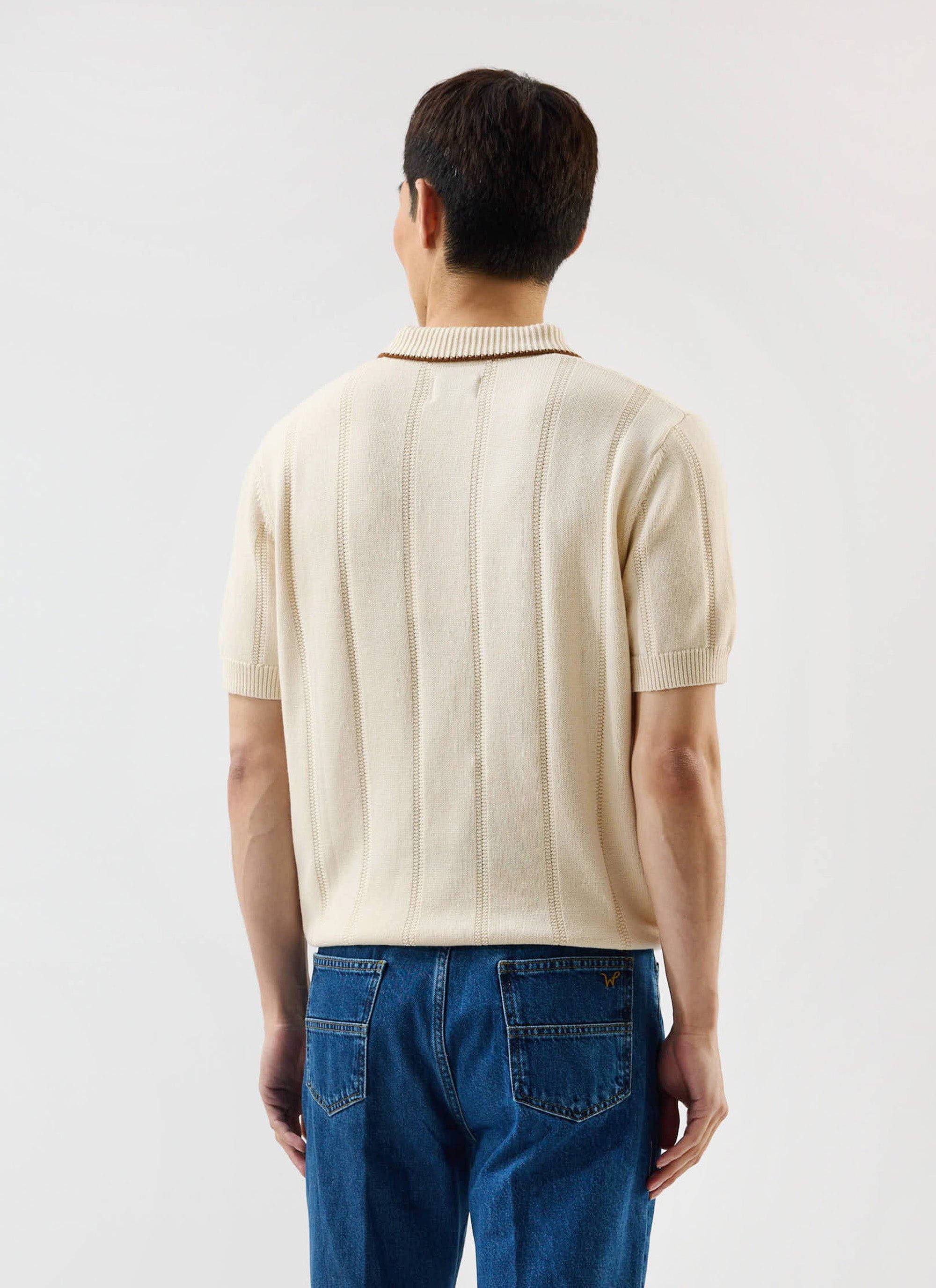 A model wears the Percival x Warren Alfie Baker ecru knitted polo shirt, seen from behind to showcase the textured knit.