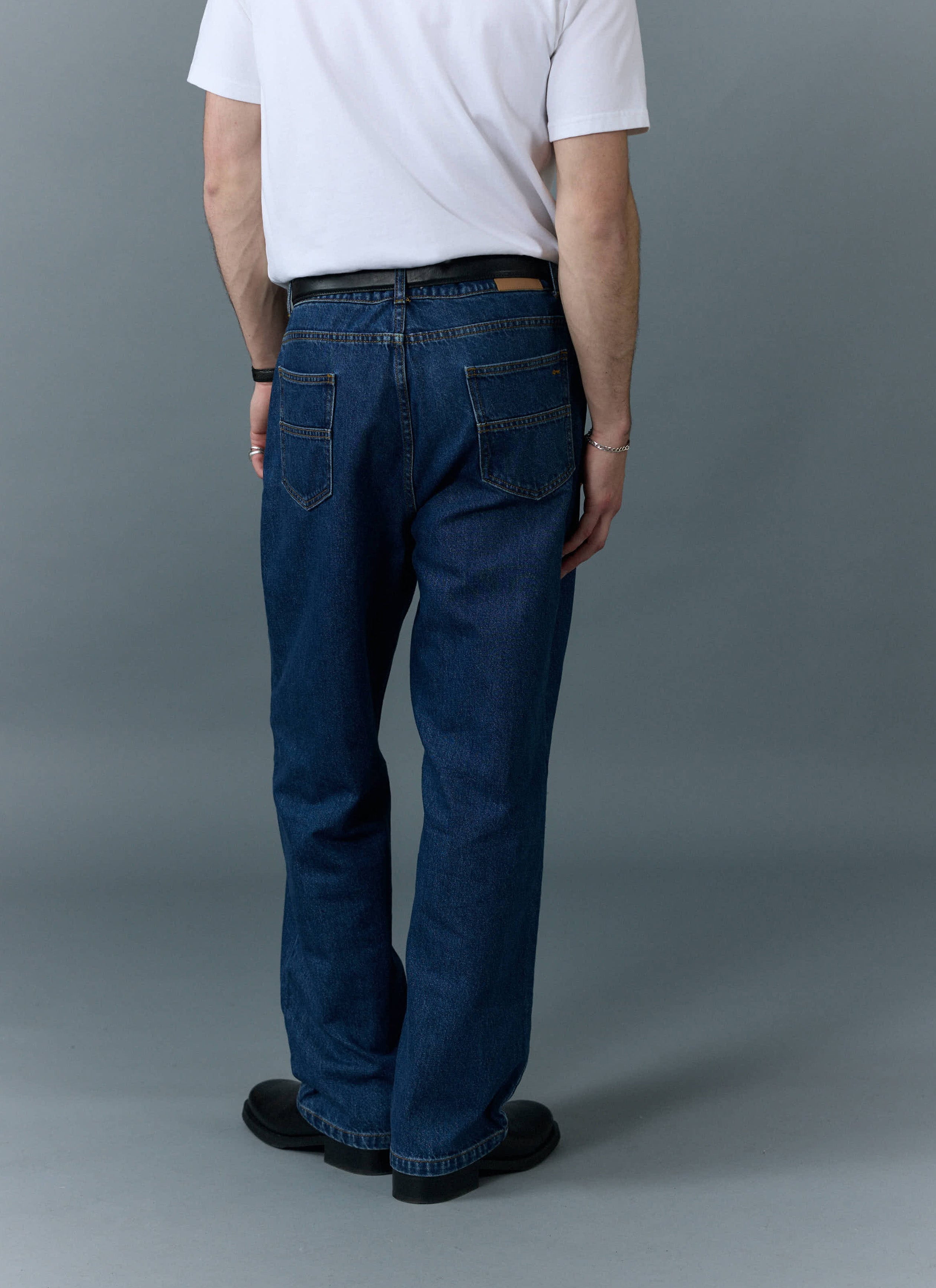 Back view of a model wearing the Percival Wide Leg Denim Jeans in mid wash blue, highlighting the relaxed, comfortable fit.