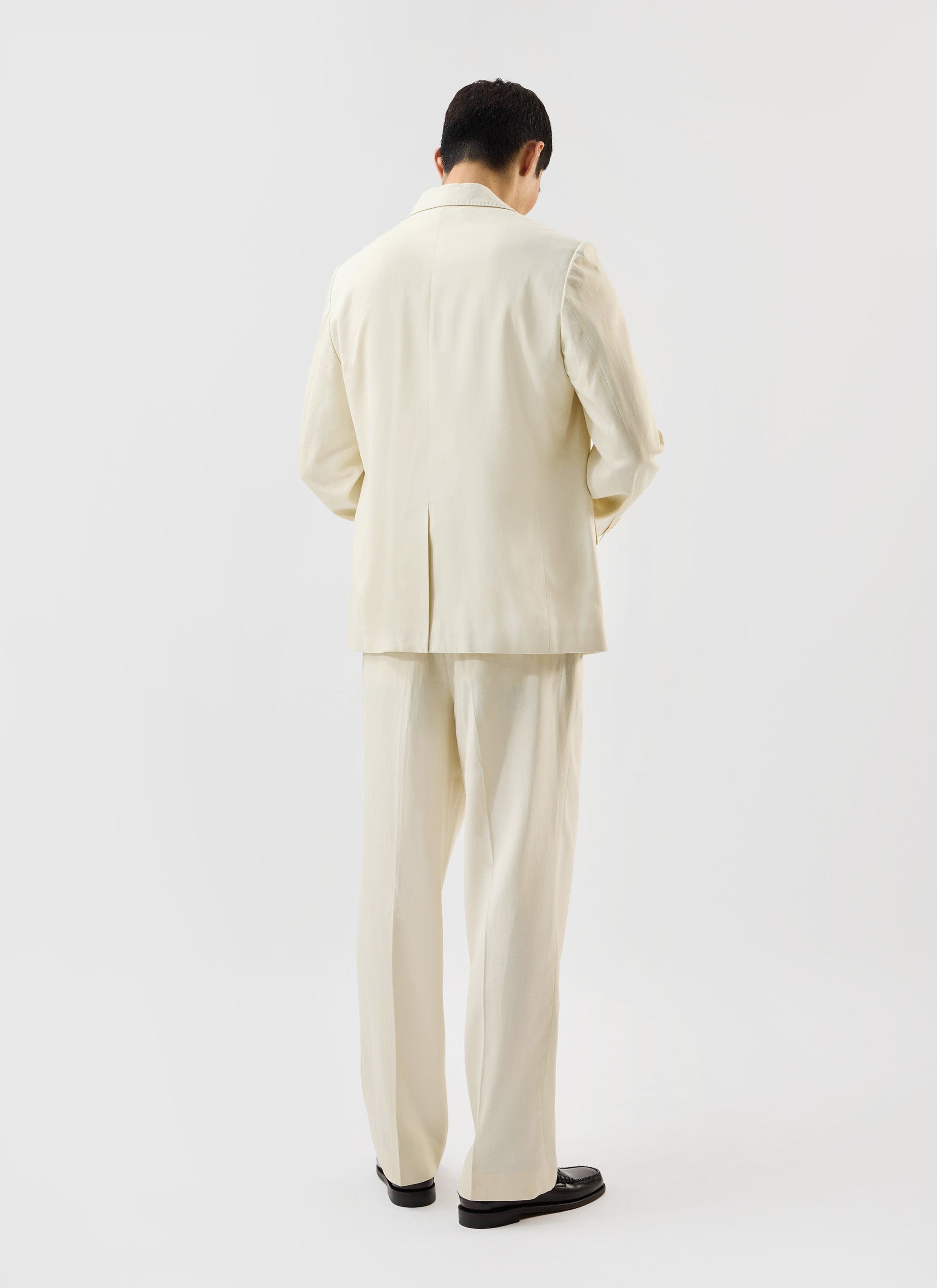 Back view of a model wearing the ecru Lyocell Tailored Blazer and matching trousers from the Percival x Warren collection.