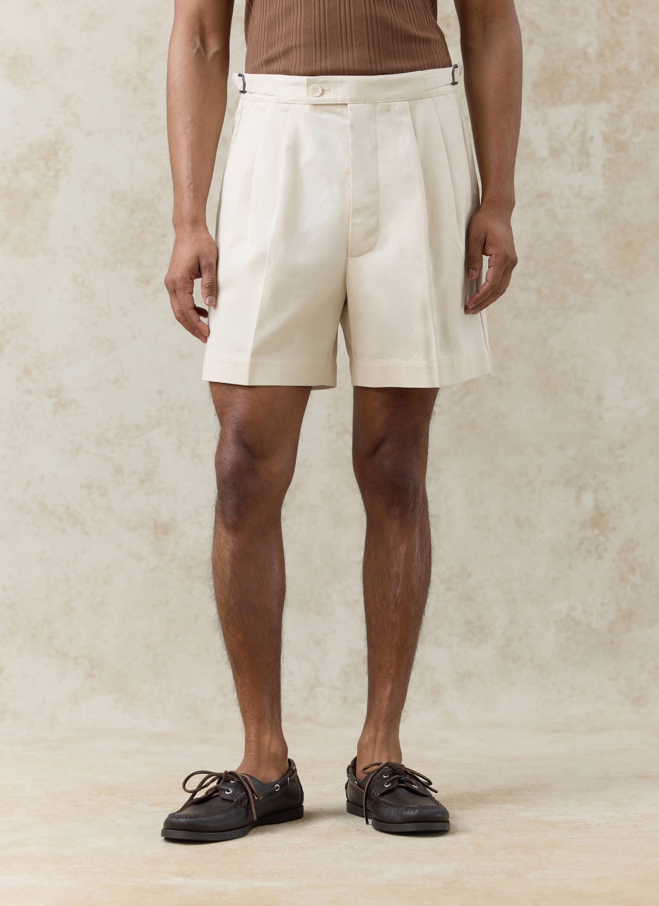 Percival cream Blake double pleated cotton shorts featuring side adjusters, styled with dark brown boat shoes.