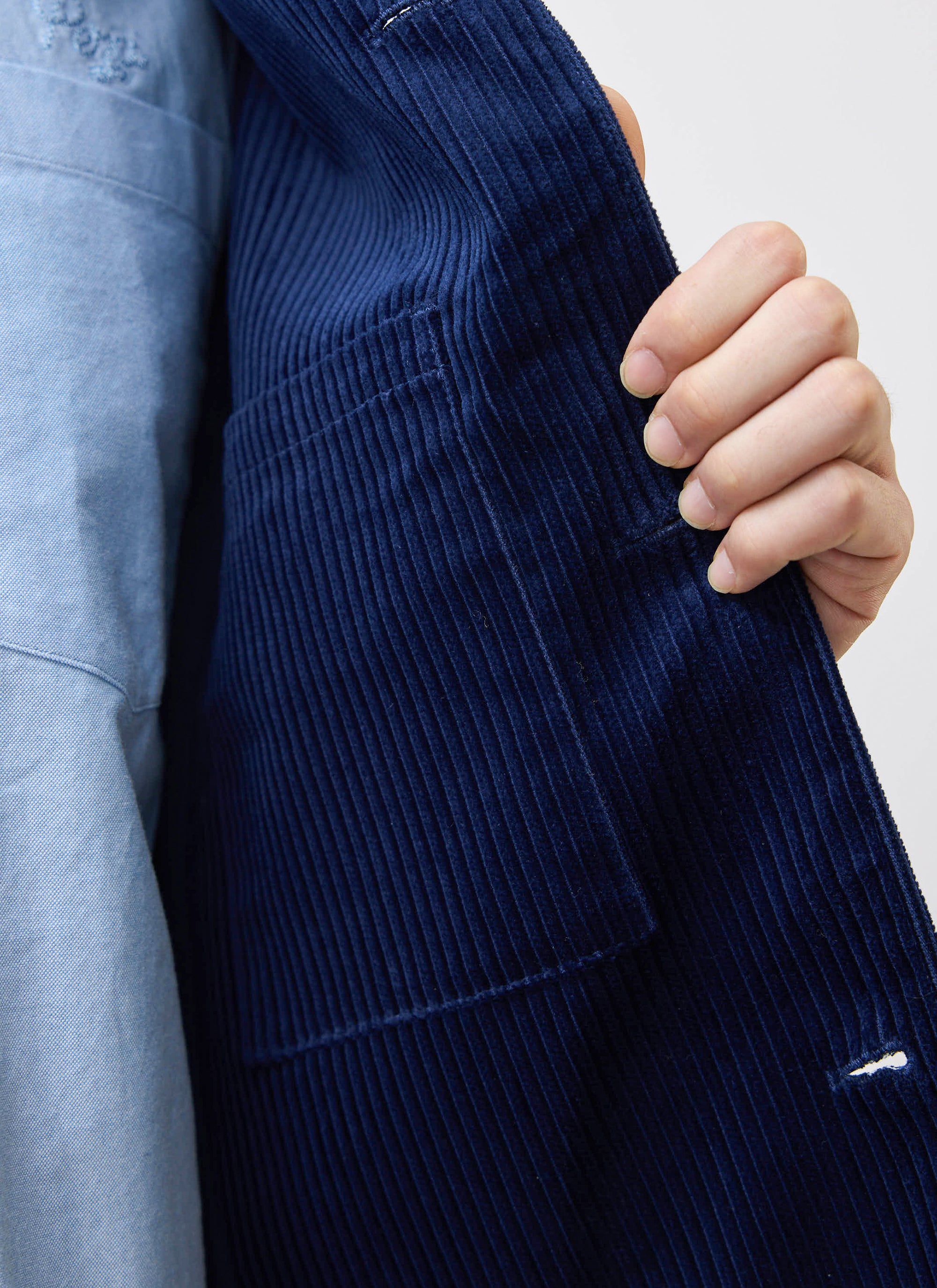 A close-up of the Percival navy cord overshirt, showing the internal pocket detail and heavyweight corduroy fabric.