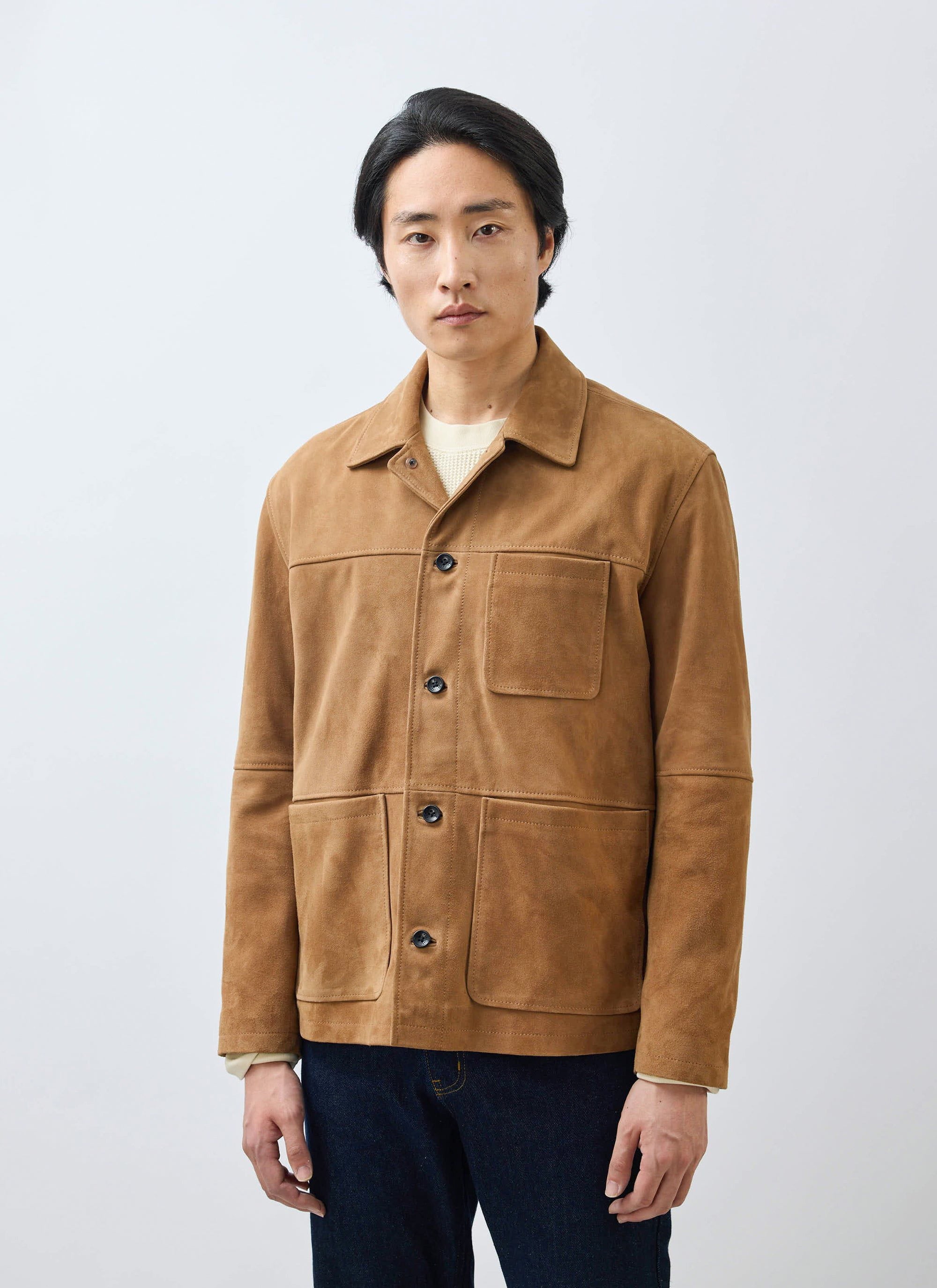 A model wears the Percival Afterward Suede Chore Jacket in tan over a cream knit against a white background.