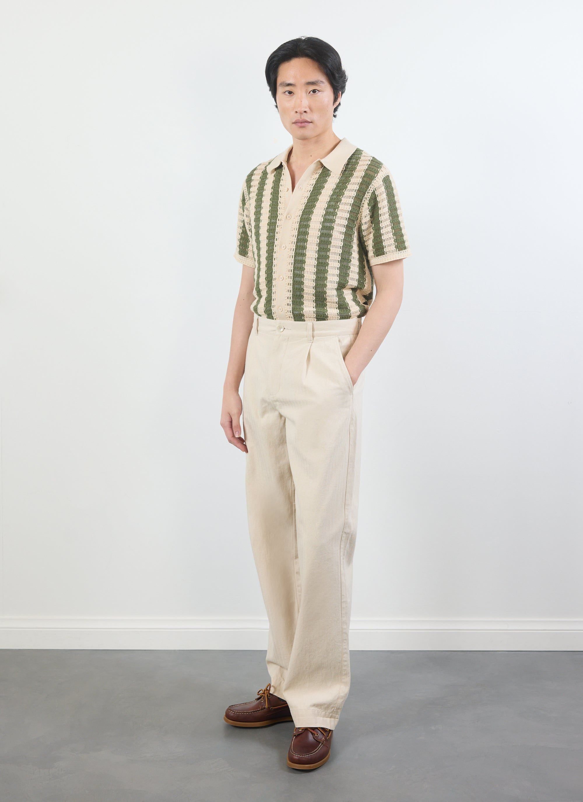 A model wears the Percival Barletta Knitted Shirt in olive green and cream, paired with light-coloured trousers.
