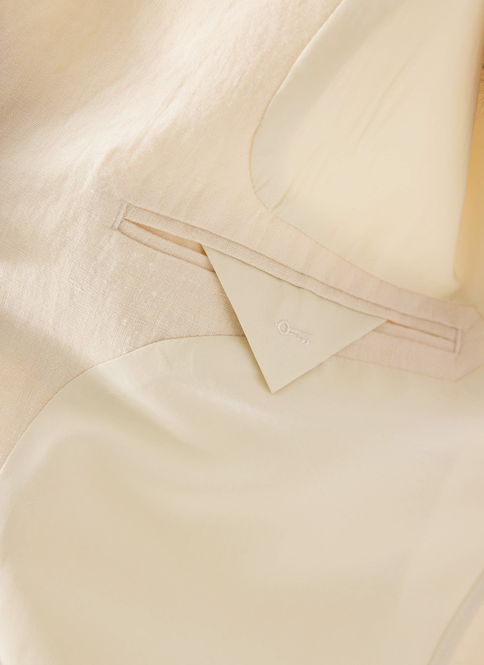 A close-up of the internal pocket and smart lining of the Percival Relaxed Linen Overshirt in stone.