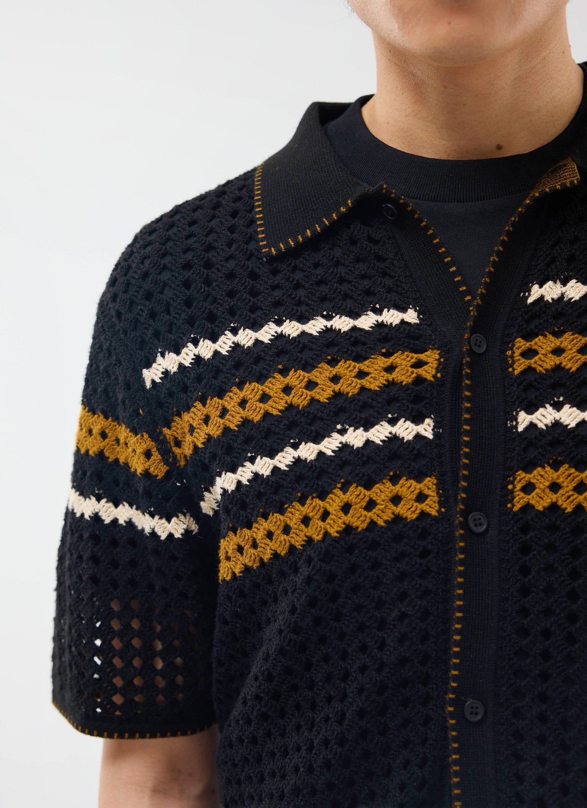 Detailed shot of the Percival Pesaro Knitted Shirt in black, showing the crochet knit, chest stripes and collar stitching.