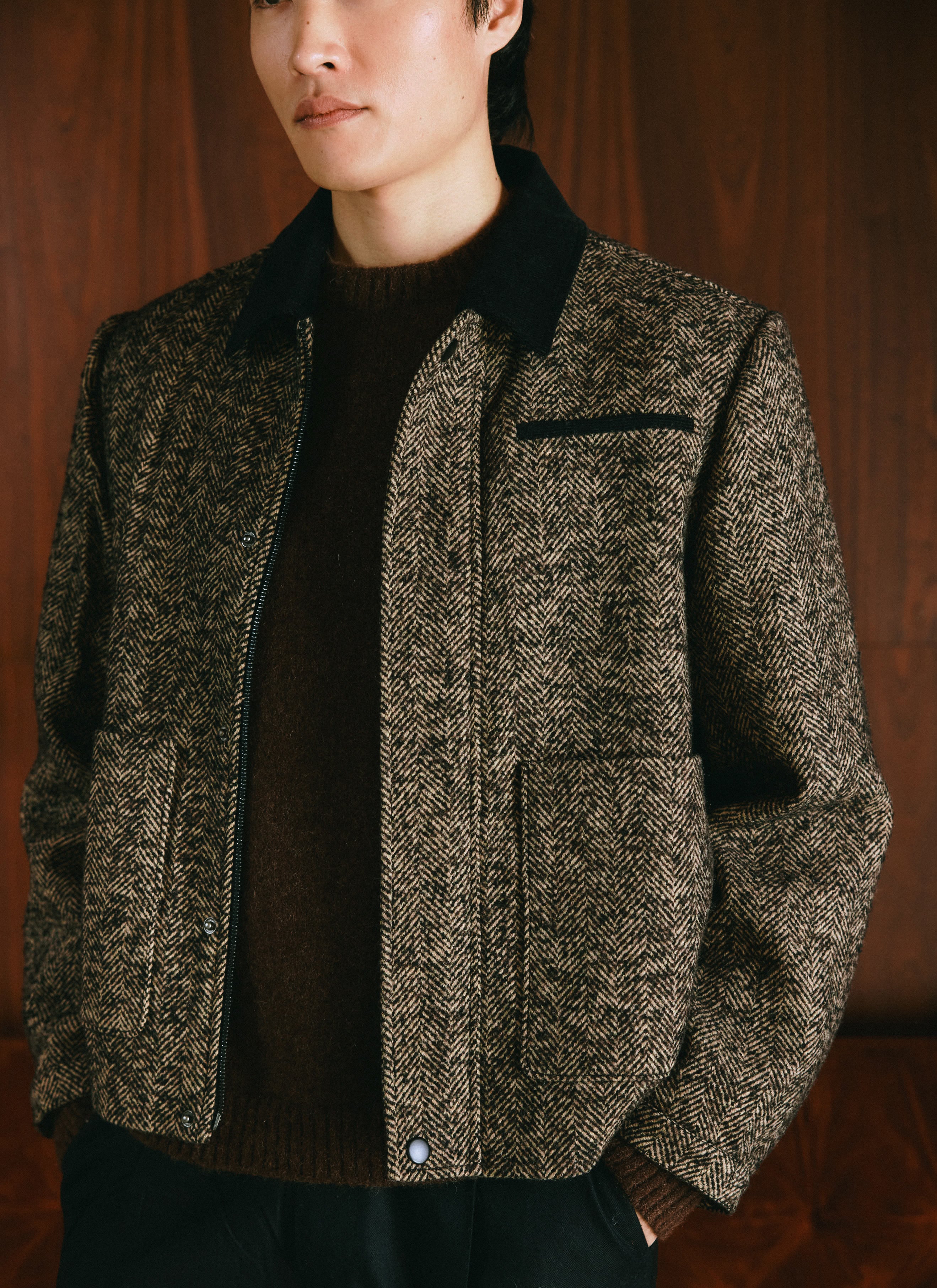 A model wears the Percival dark brown herringbone wool blend boxy jacket featuring a contrast collar and front pockets.