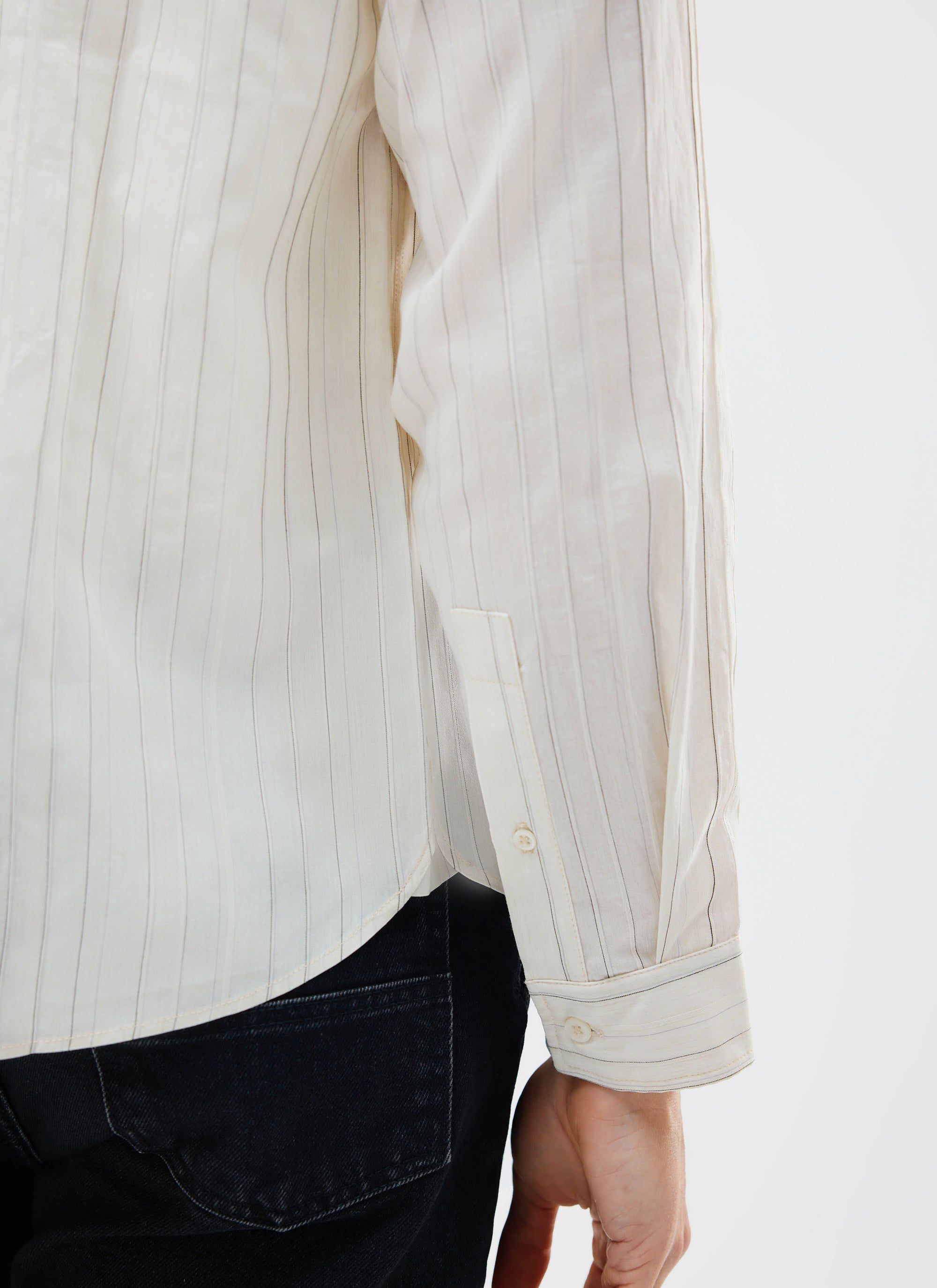 A close-up of a model wearing the ecru striped Lorenzo Pearce Shirt from Percival, showing the sleeve and cuff detail.