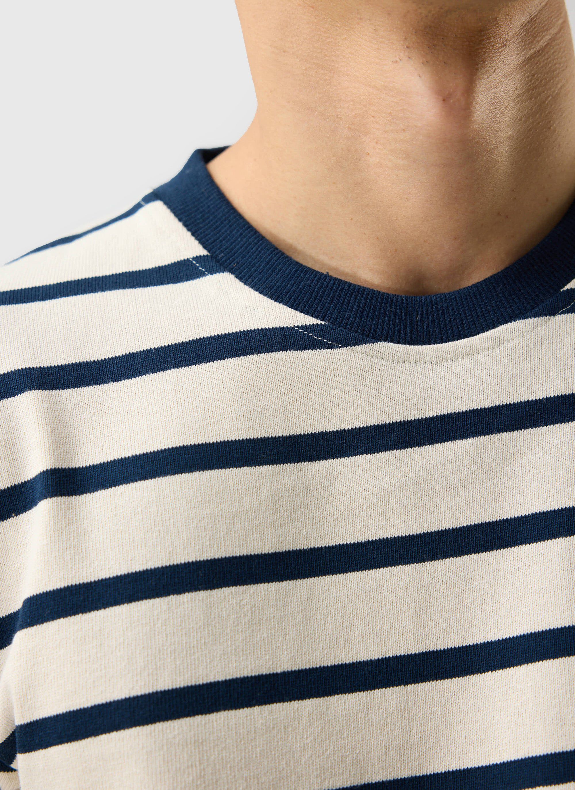 Close up of the Percival Breton Stripe T-shirt in ecru and navy, showing the ribbed collar and organic cotton fabric.