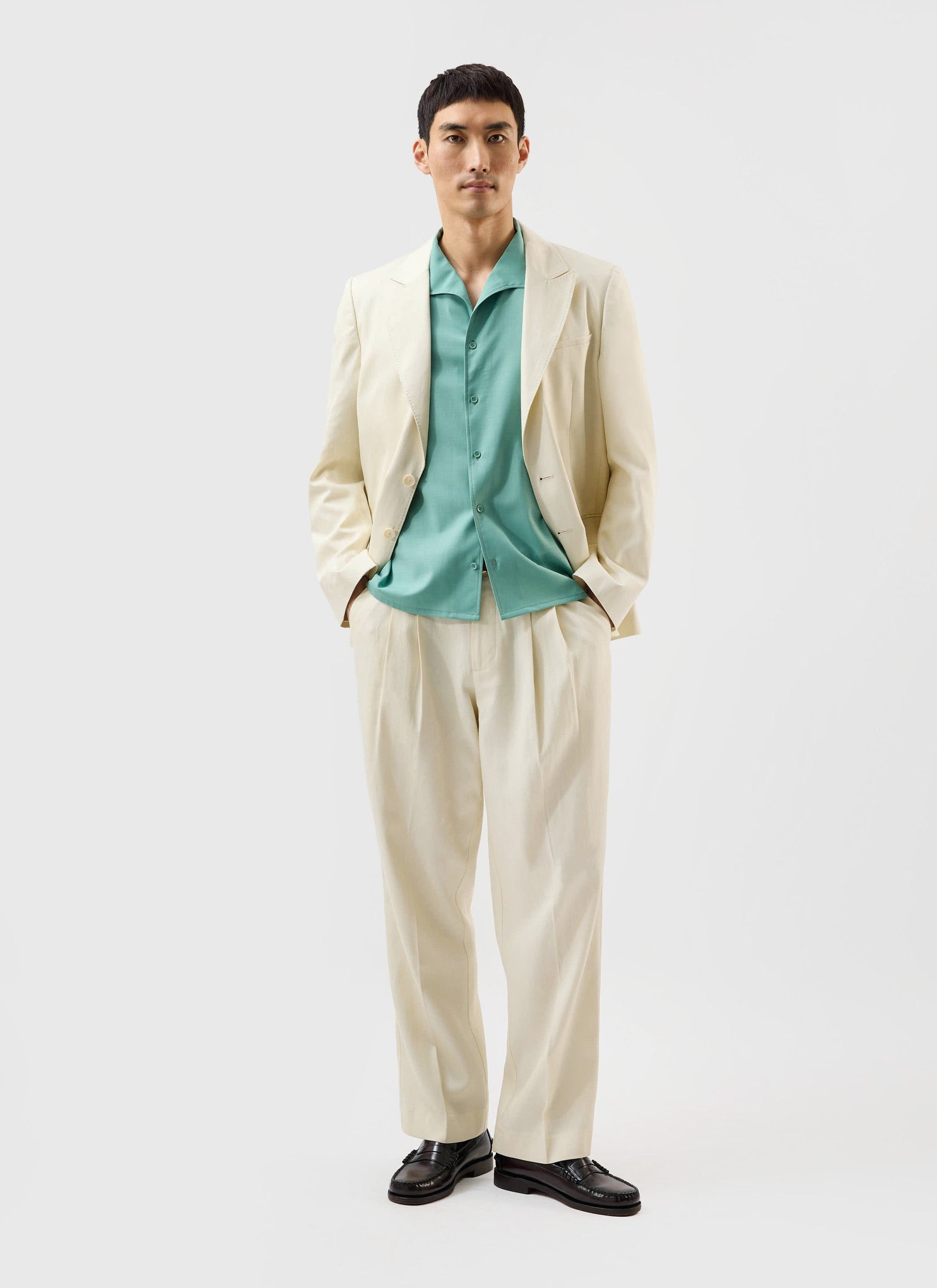 A model wears the Percival x Warren Drape Cuban Shirt in mint green, styled under an off-white suit.