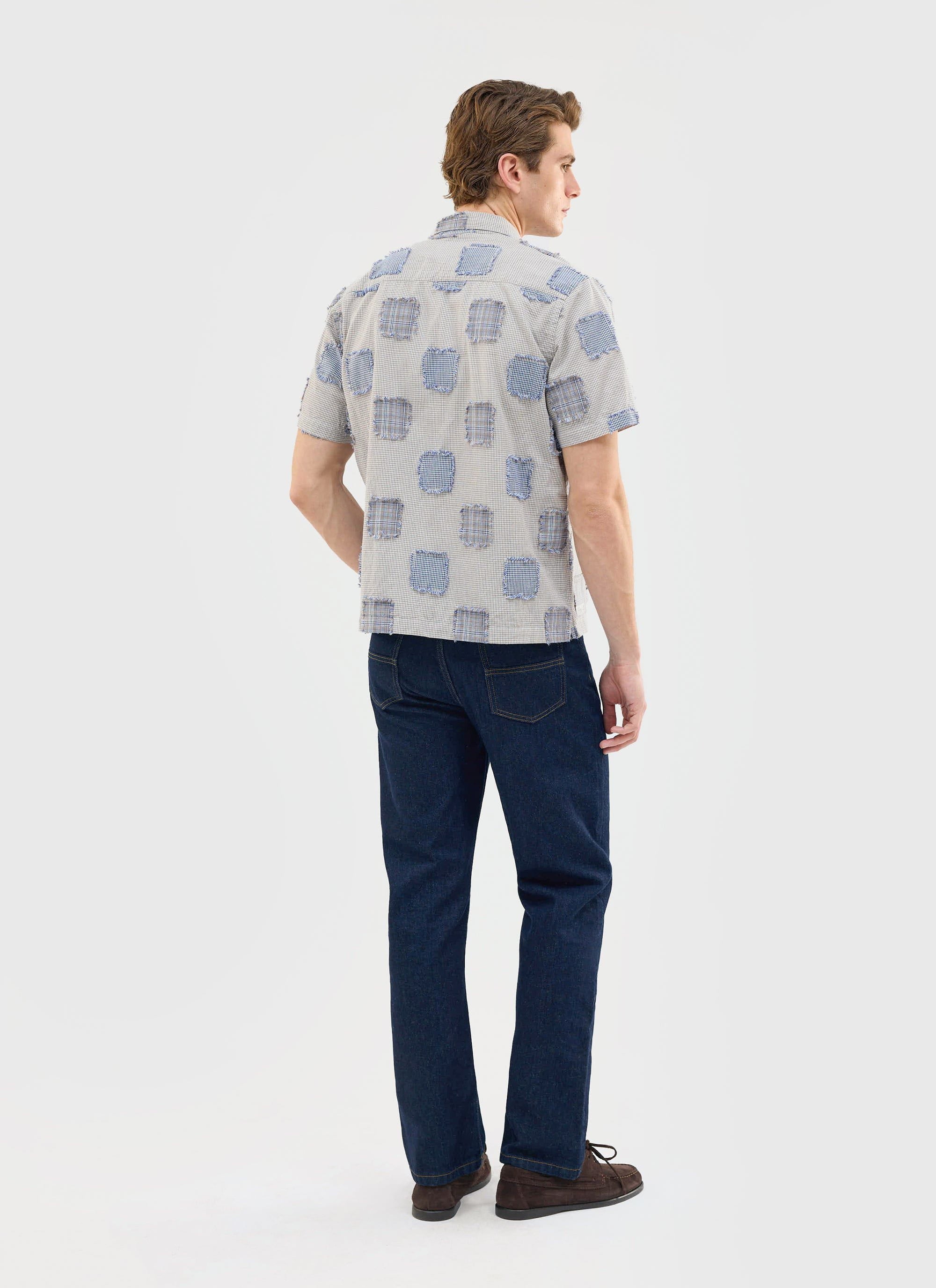 Back view of a model wearing the Percival Bruno Boxy Clerk Shirt in grey, showcasing the unique patchwork flannel design.