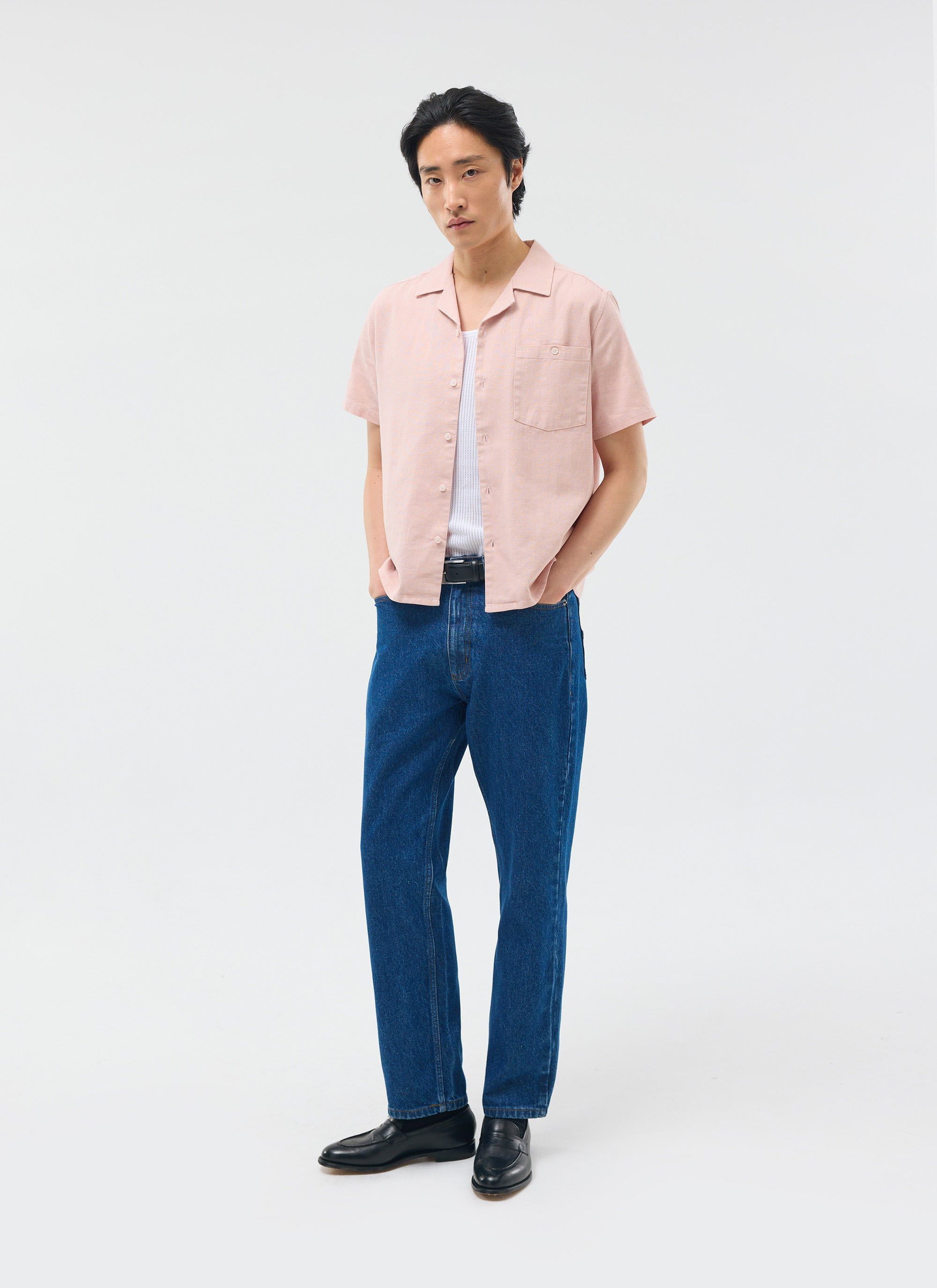 The Percival Short Sleeve Cuban Shirt in dusty pink linen, styled on a model with a white vest and dark blue jeans.