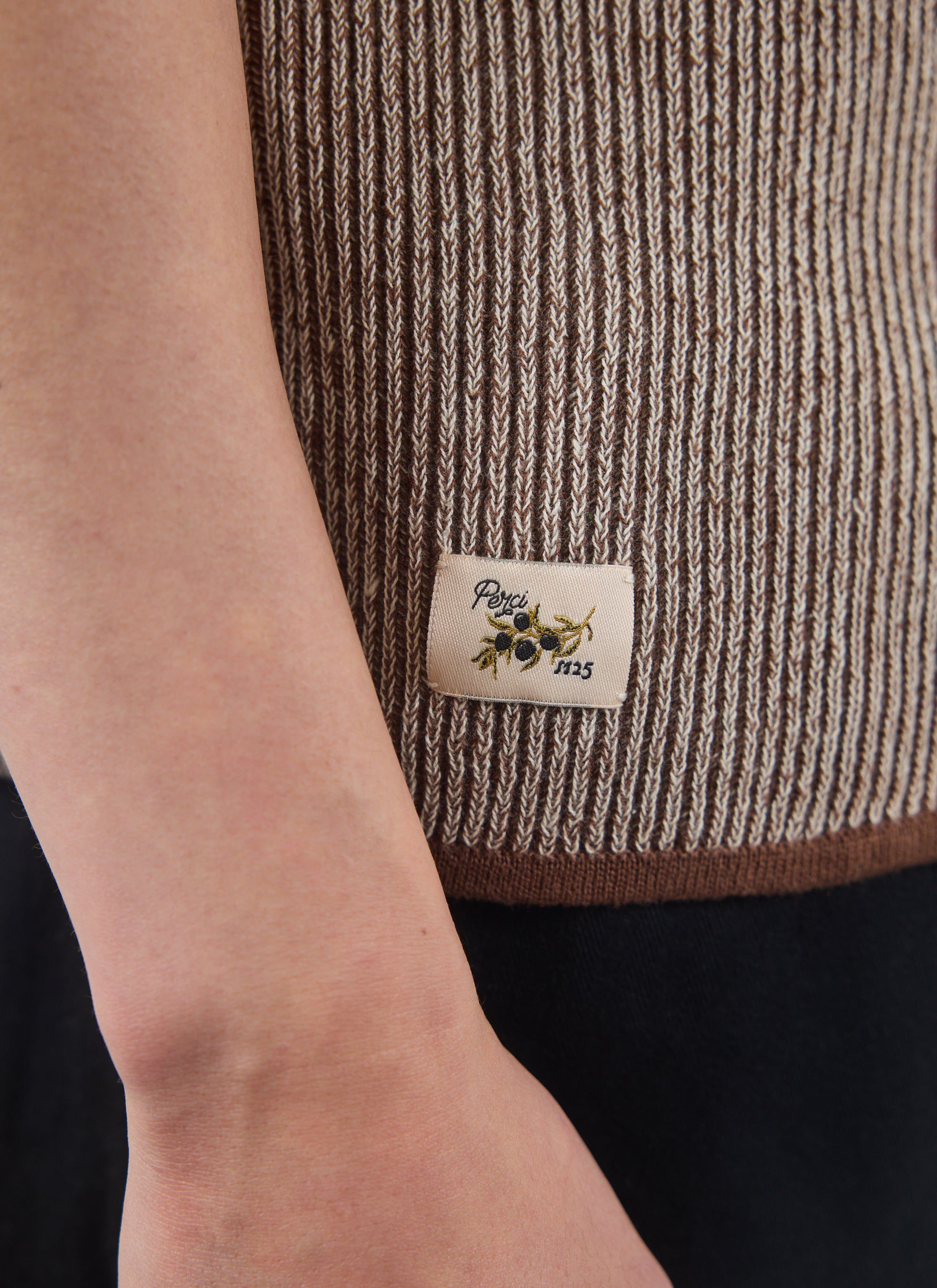 A close-up of the Percival Teramo Knitted Polo, showing the brown and ecru ribbed knit and the signature embroidered label.