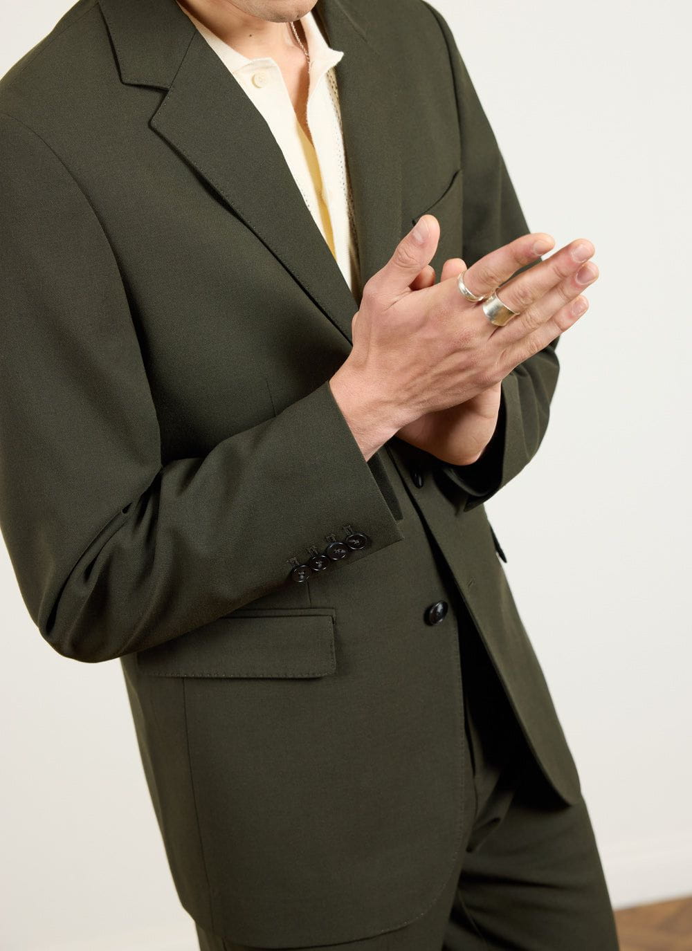 Close up detail of the Percival tailored wool blazer in forest green showing the sleeve buttons and lapel