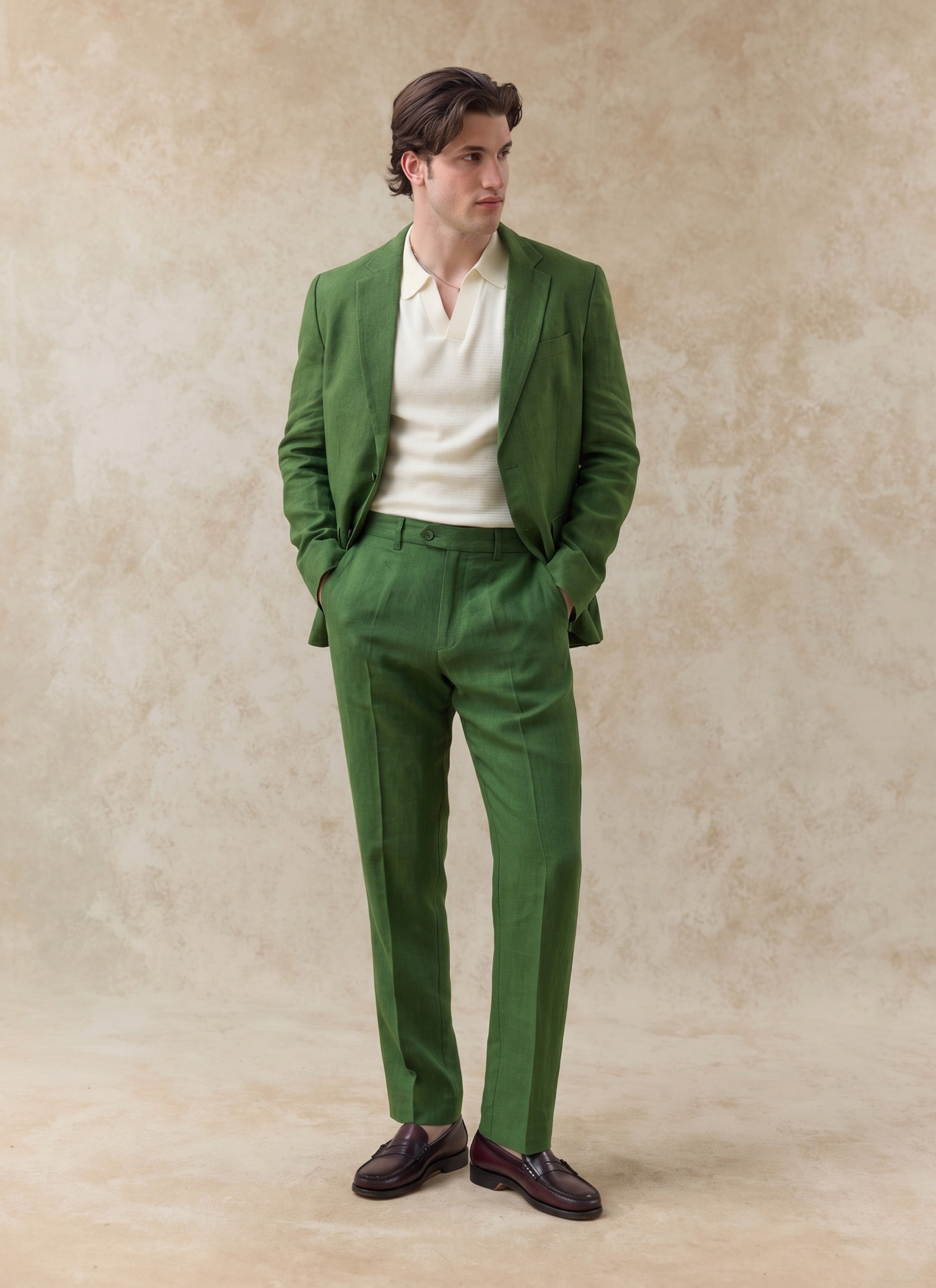 Tailored forest green linen blazer and matching suit trousers from Percival, styled over a cream knit polo shirt.