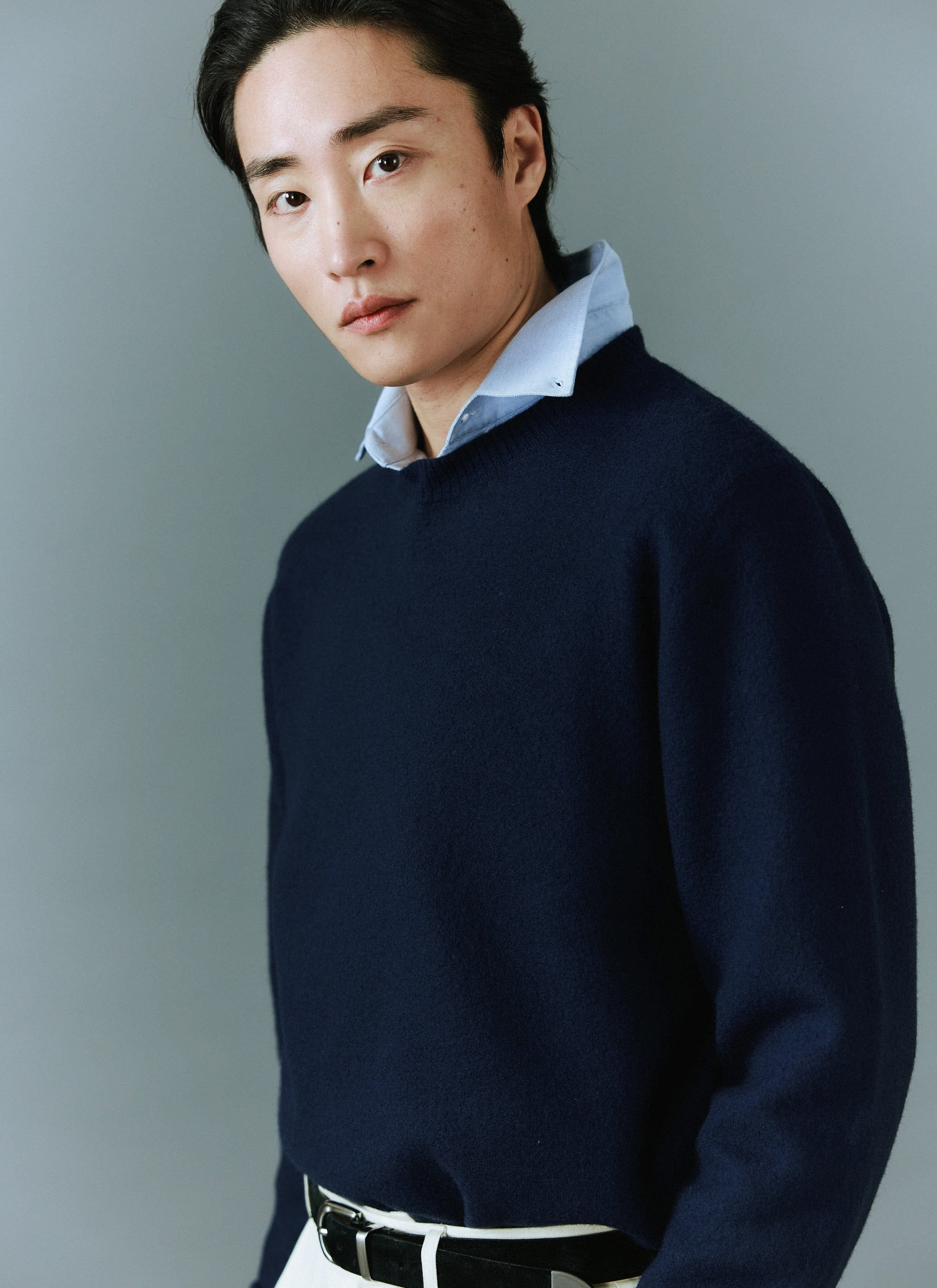 A model styles the Percival Felted Regular Jumper in navy merino wool, layered neatly over a light blue collared shirt.