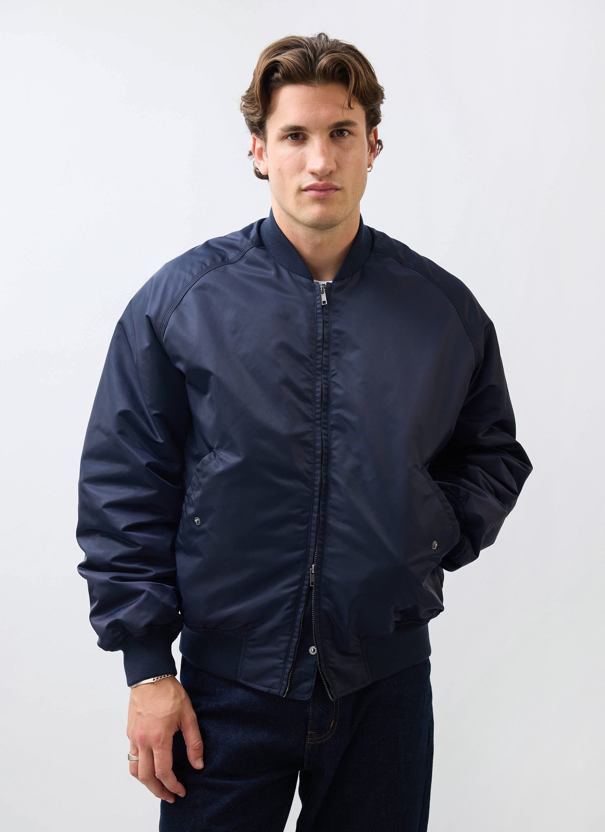 A model wears the Percival midnight navy nylon bomber jacket against a plain white background.