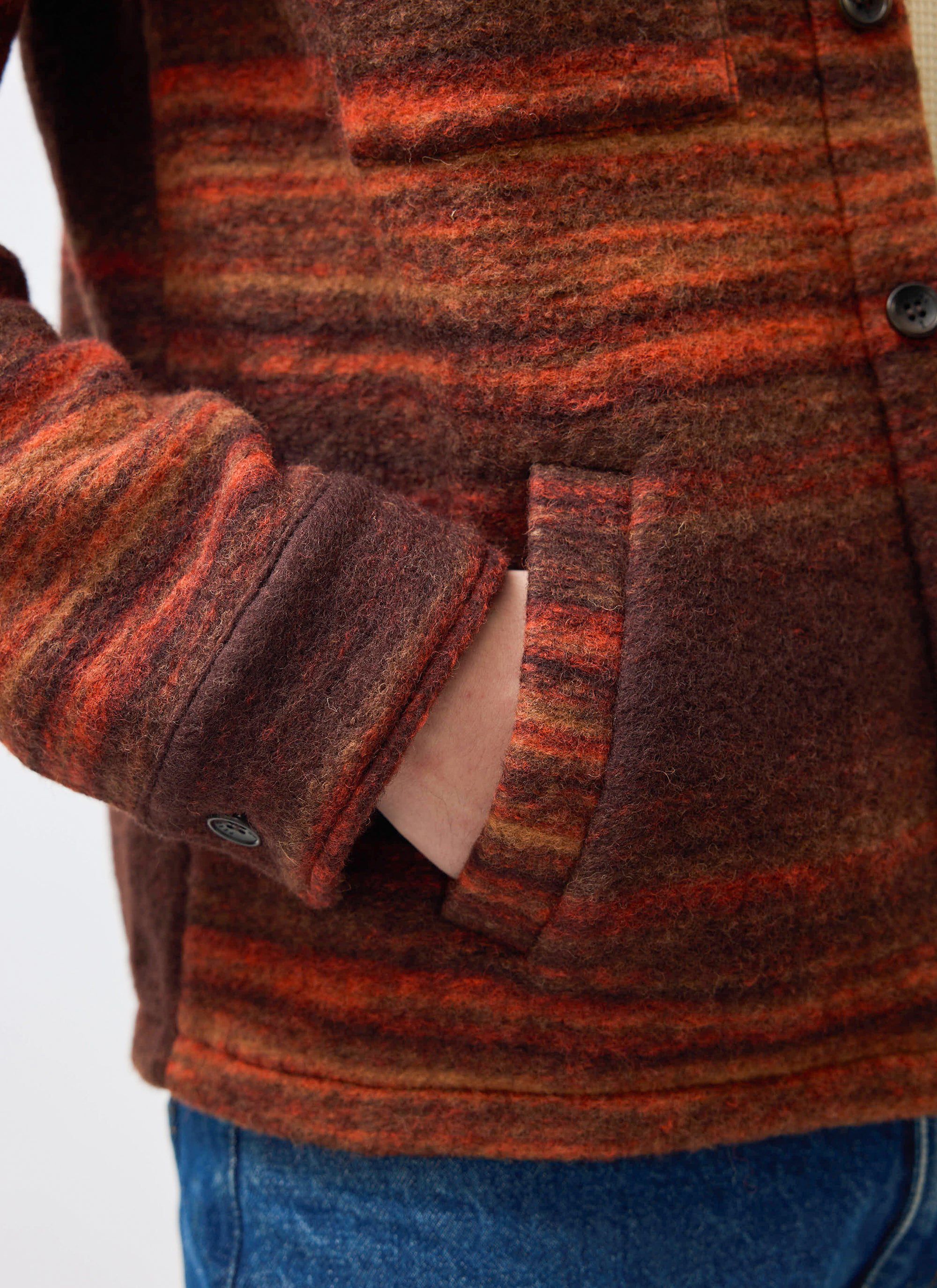 A close-up of the Percival Mississippi Jacquard Overshirt in burnt orange, showing the slip pocket and boiled wool texture.