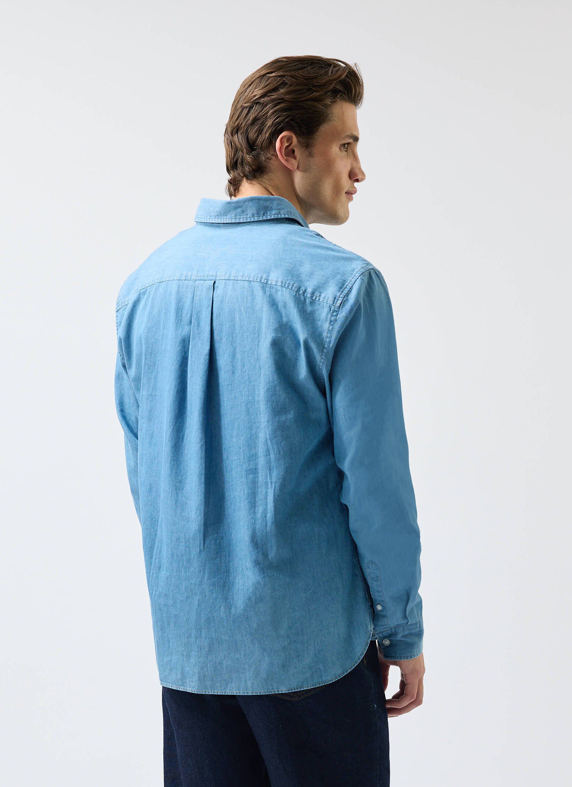 A model wears the Percival Marco Pearce denim shirt in light blue, photographed from the back against a white background.