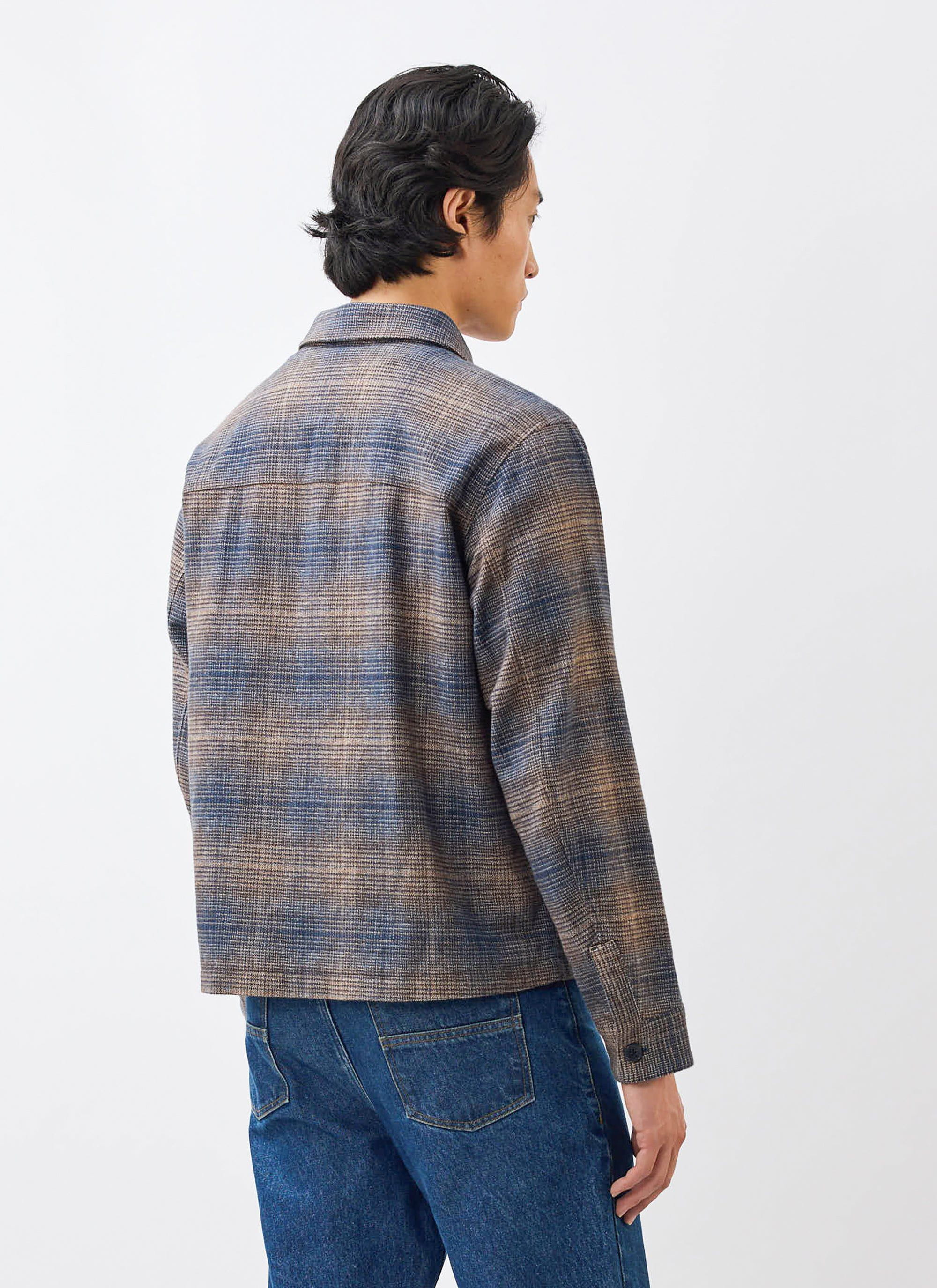 A model seen from behind, wearing the Luton Check Overshirt in brown and blue by Percival with a pair of blue jeans.