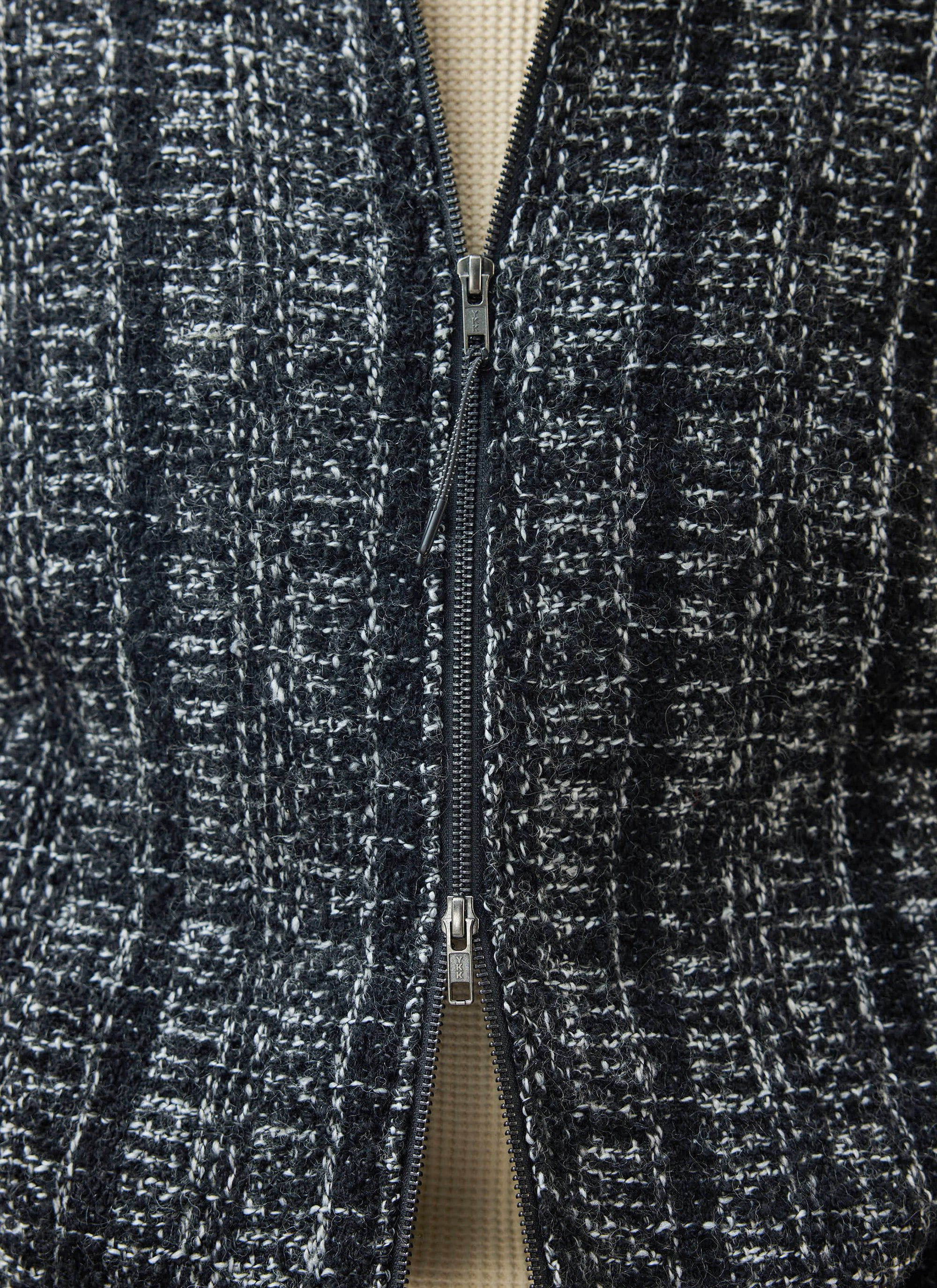 Close up of the Percival Ingegno Zip Wool Boxy Jacket in black, showing the bouclé tweed texture and two-way zip.